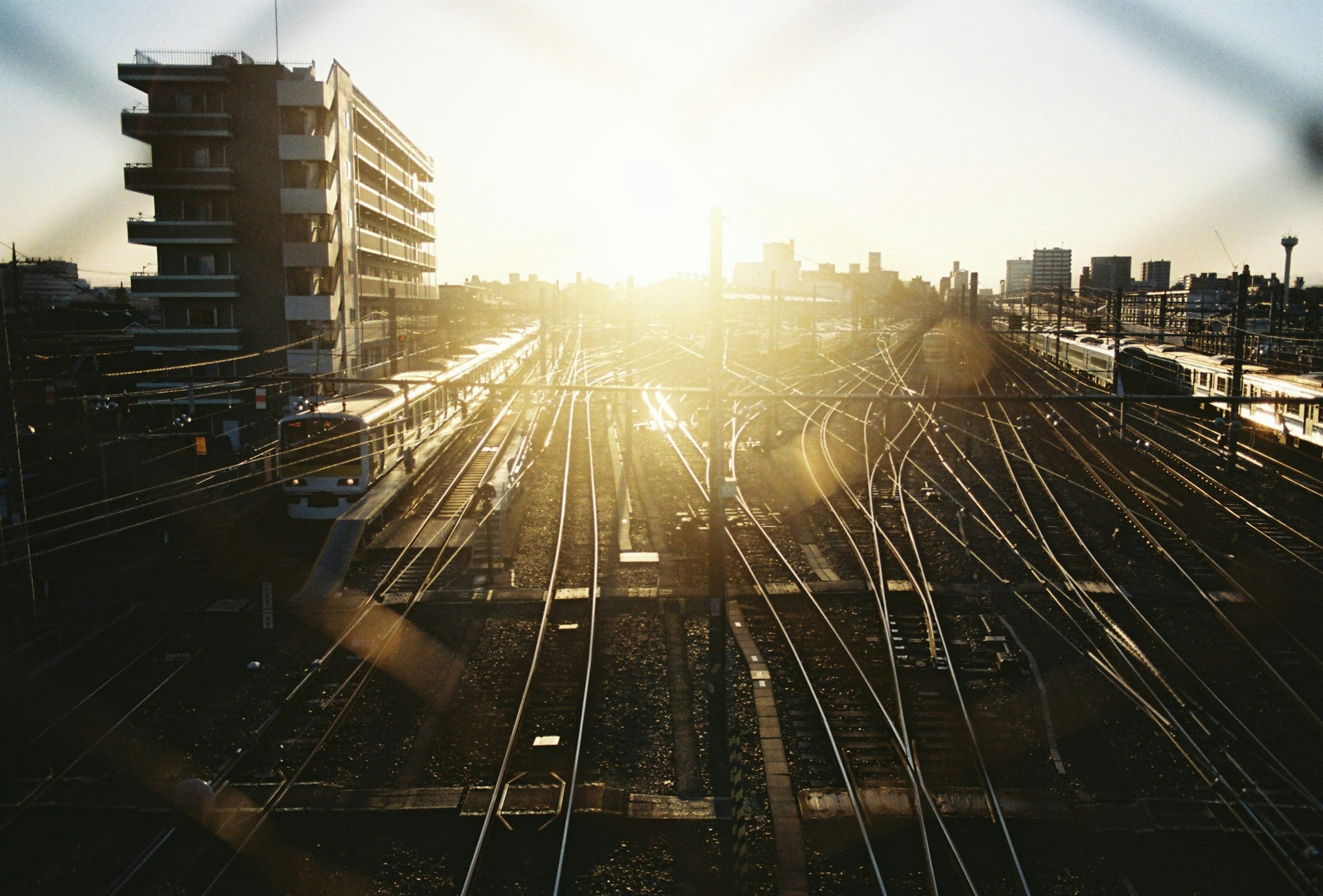 日の出の光が差し込む鉄道の風景 鉄道のレールが広がり 建物が背景に見える