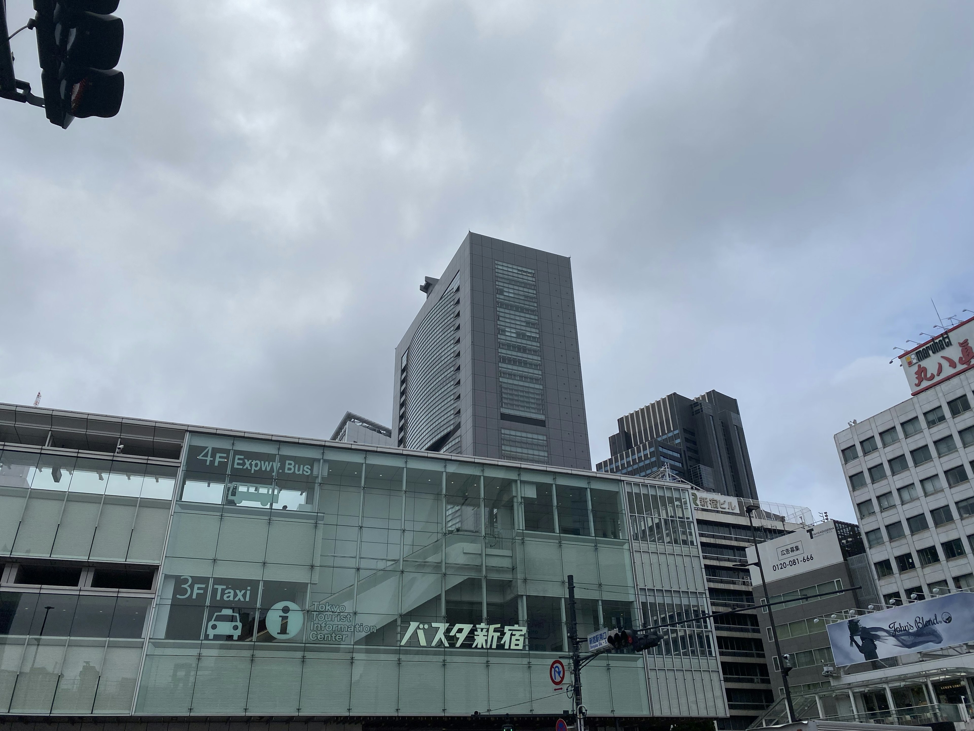 高層ビルと曇り空の都市風景 駅のガラス建築と交通信号