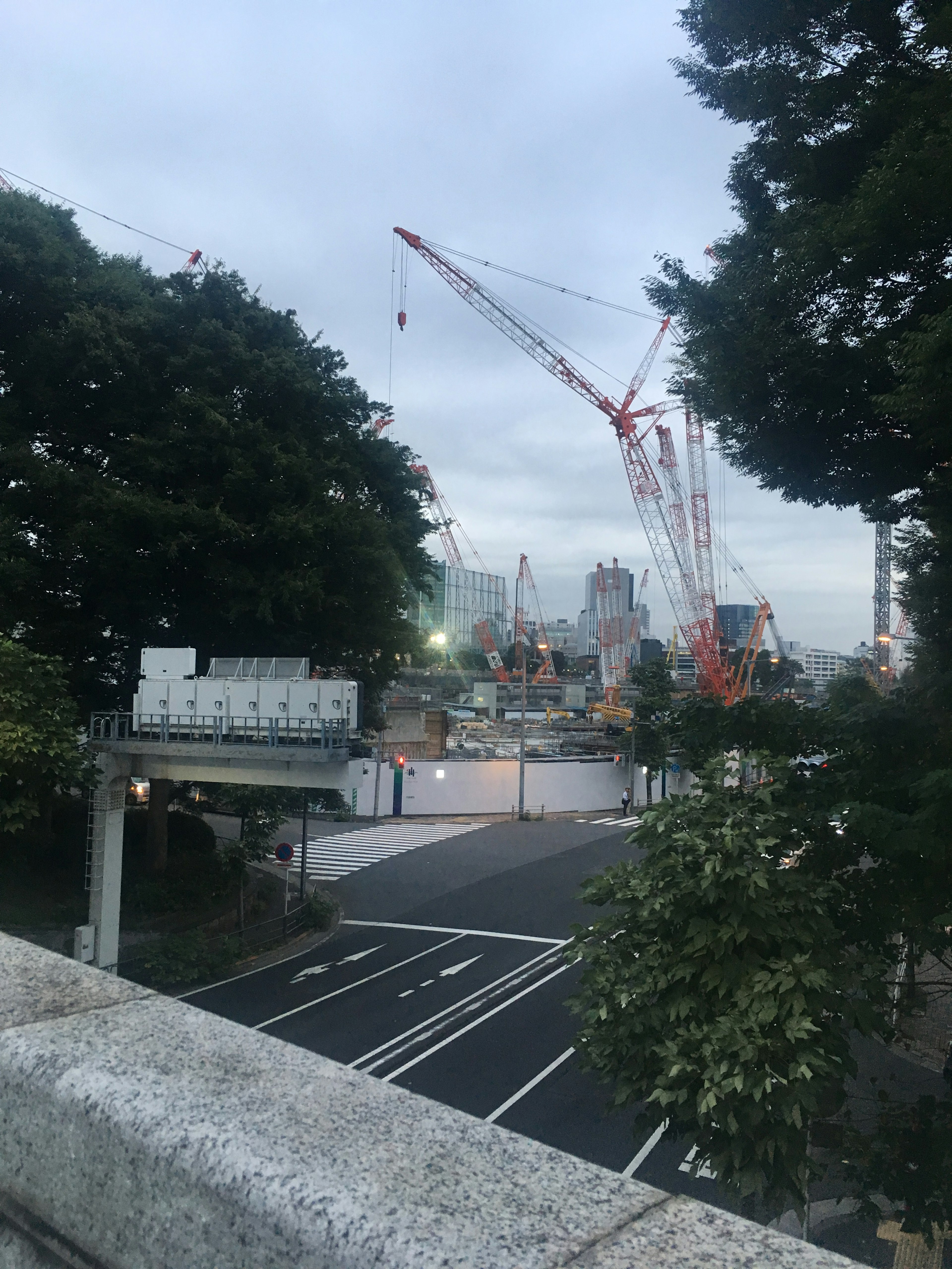 黎明前的城市風景，展現摩天大樓和起重機