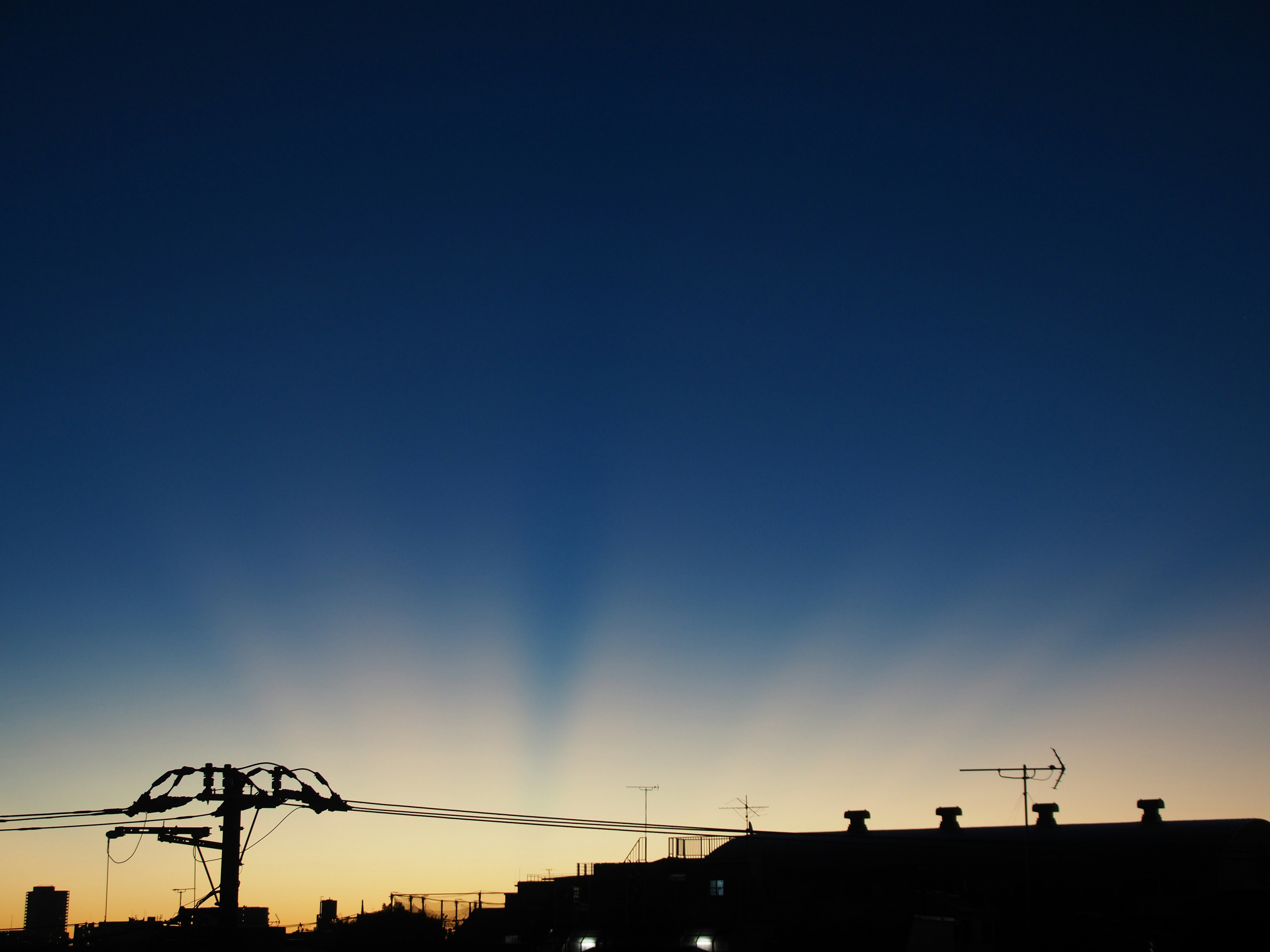 Verlauf von Blau und Orange im Abendhimmel mit silhouettierten Gebäuden