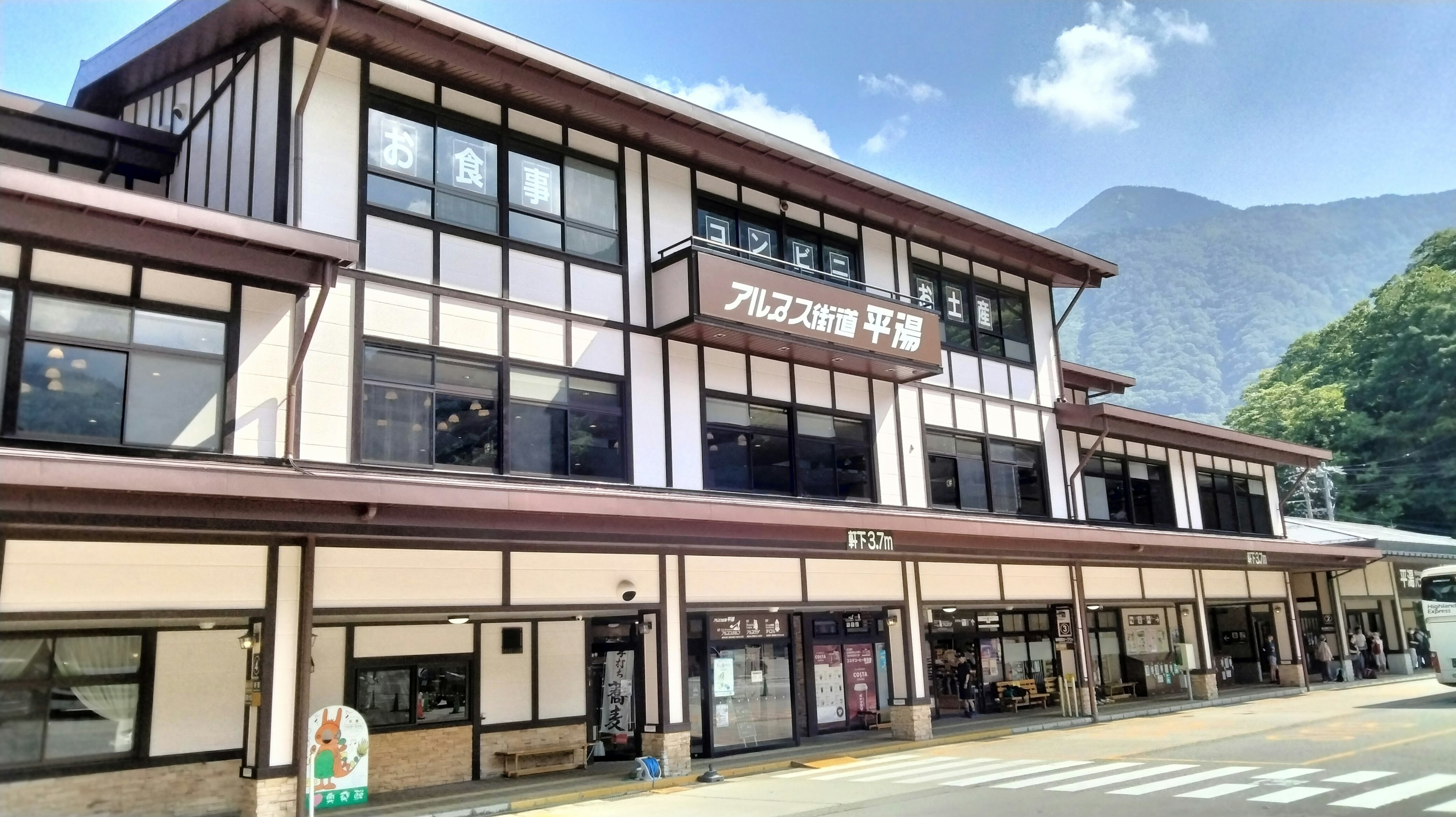 Traditional Japanese train station building with mountain backdrop