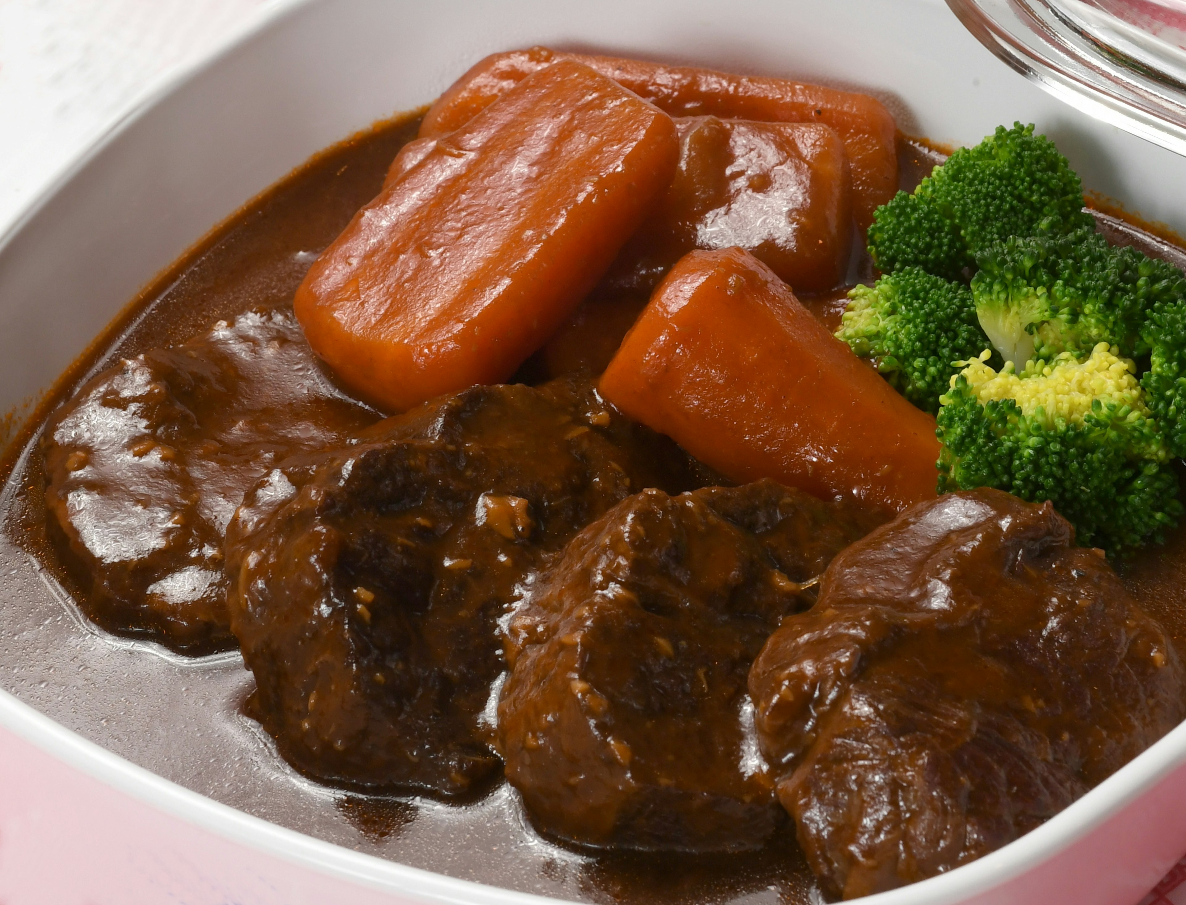 A plate of braised meat with carrots and broccoli