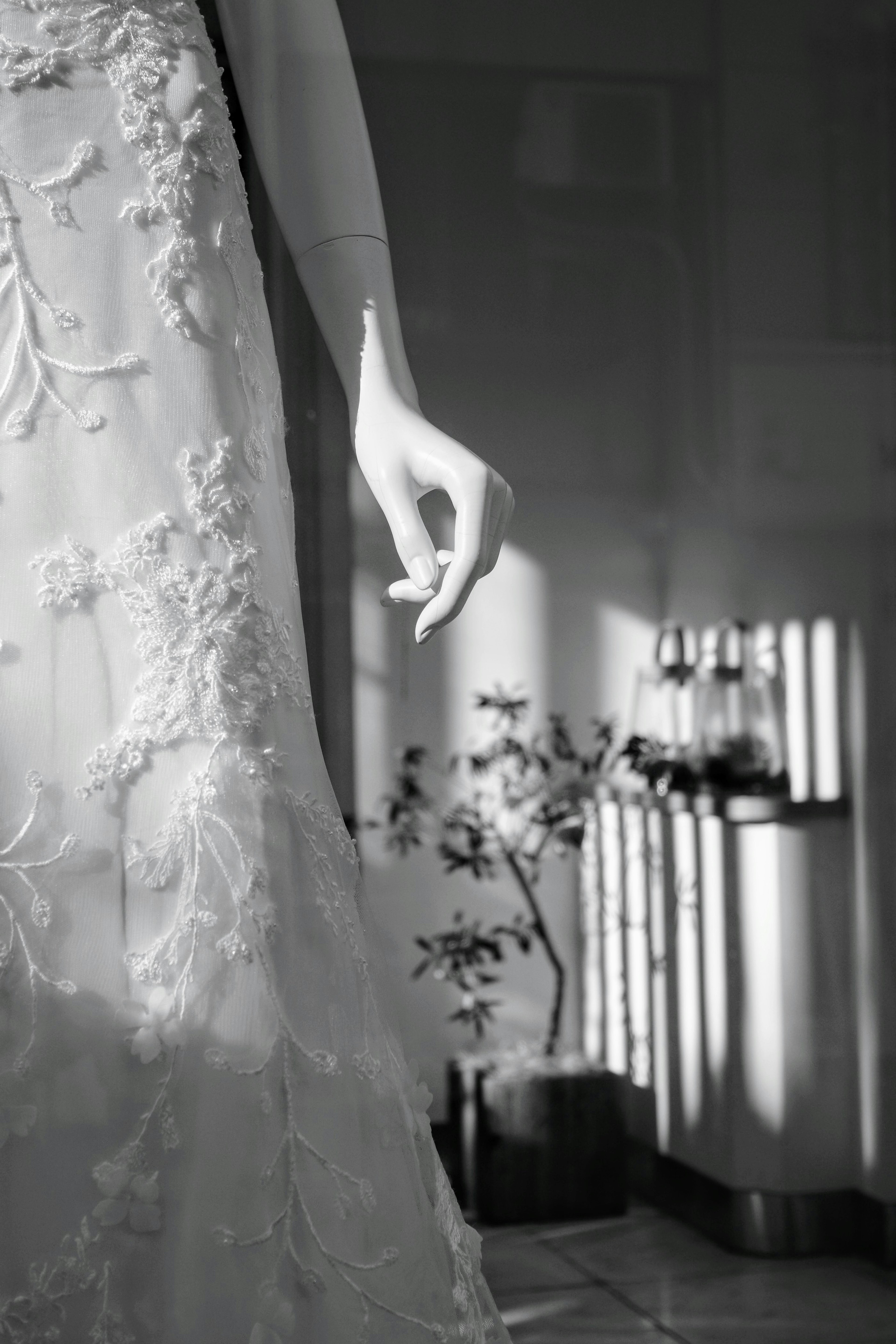 Primer plano de un vestido en blanco y negro con una mano bordado delicado y luz suave