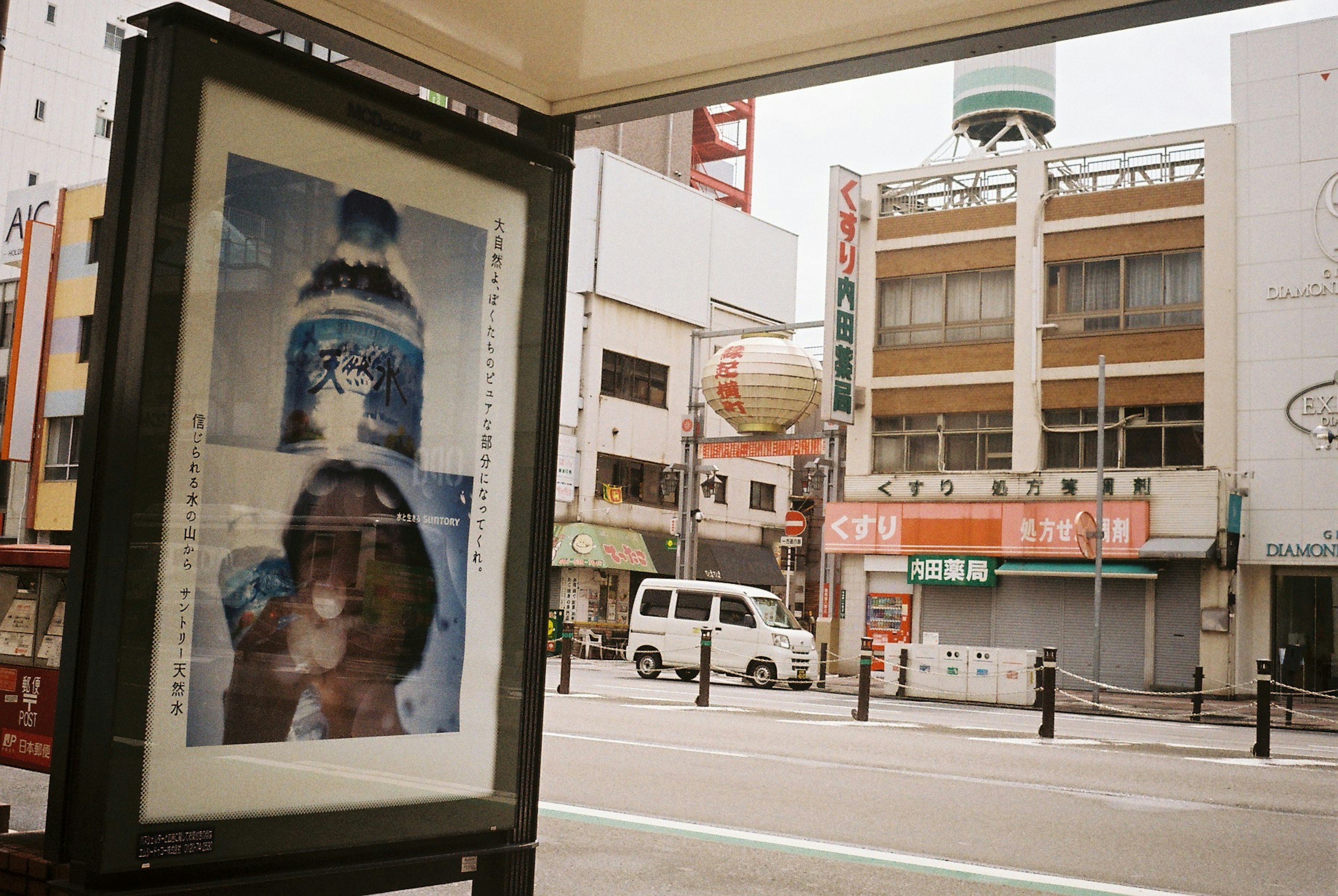 Street corner advertisement featuring a water bottle and a woman's face