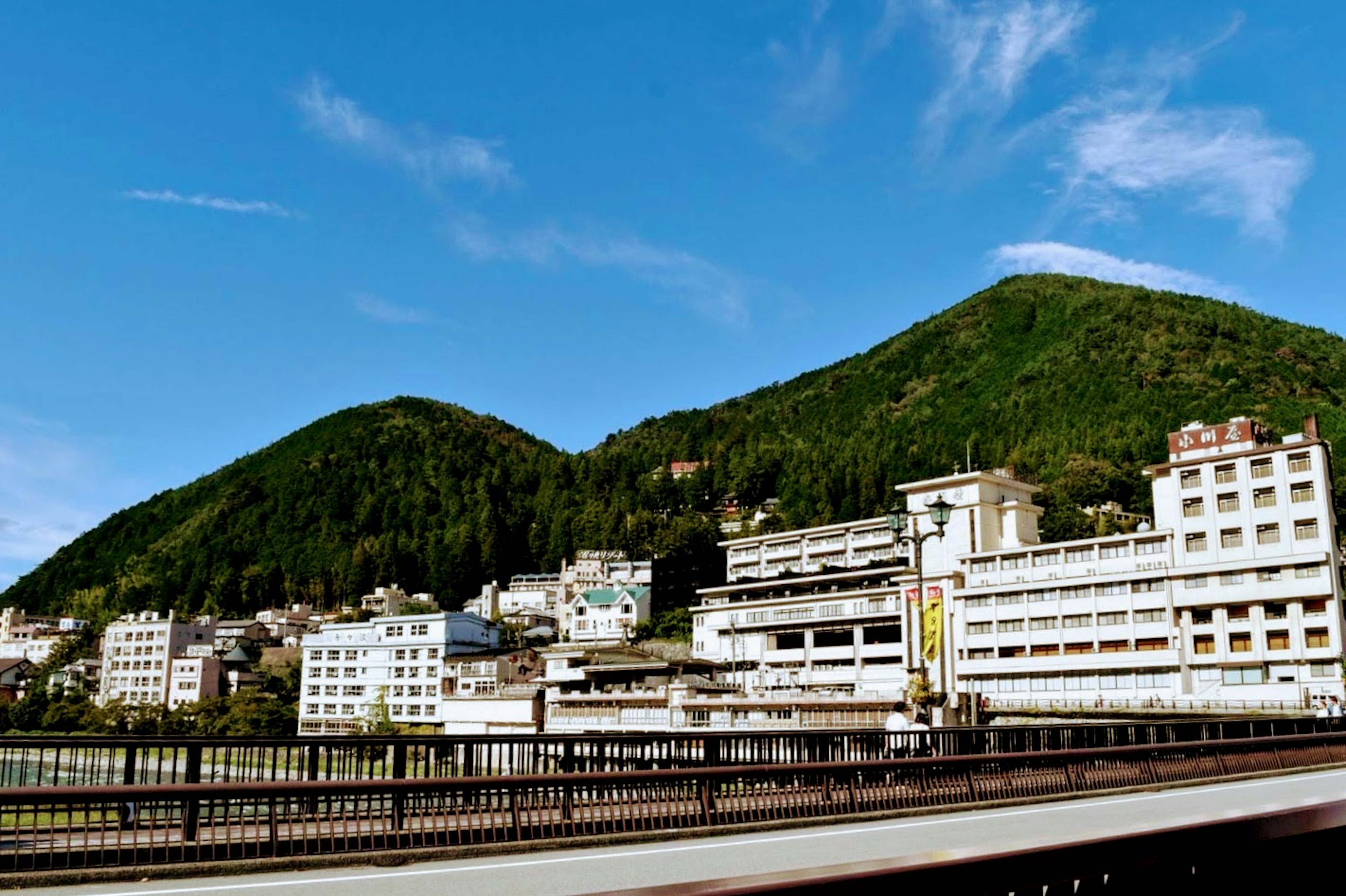 Scenic view of a hot spring town surrounded by green mountains