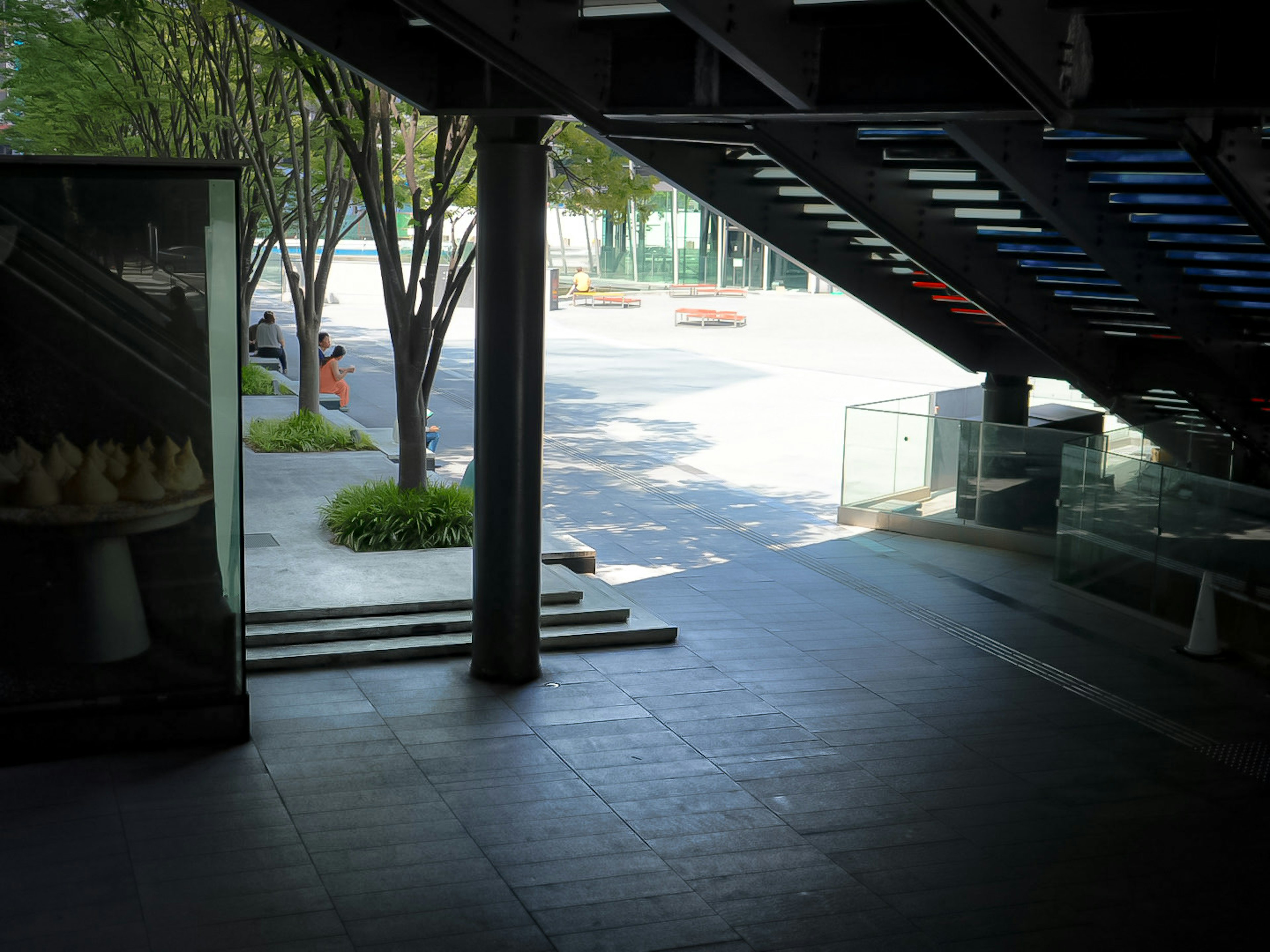 Vue d'une rue calme et d'arbres verts depuis l'entrée d'un bâtiment