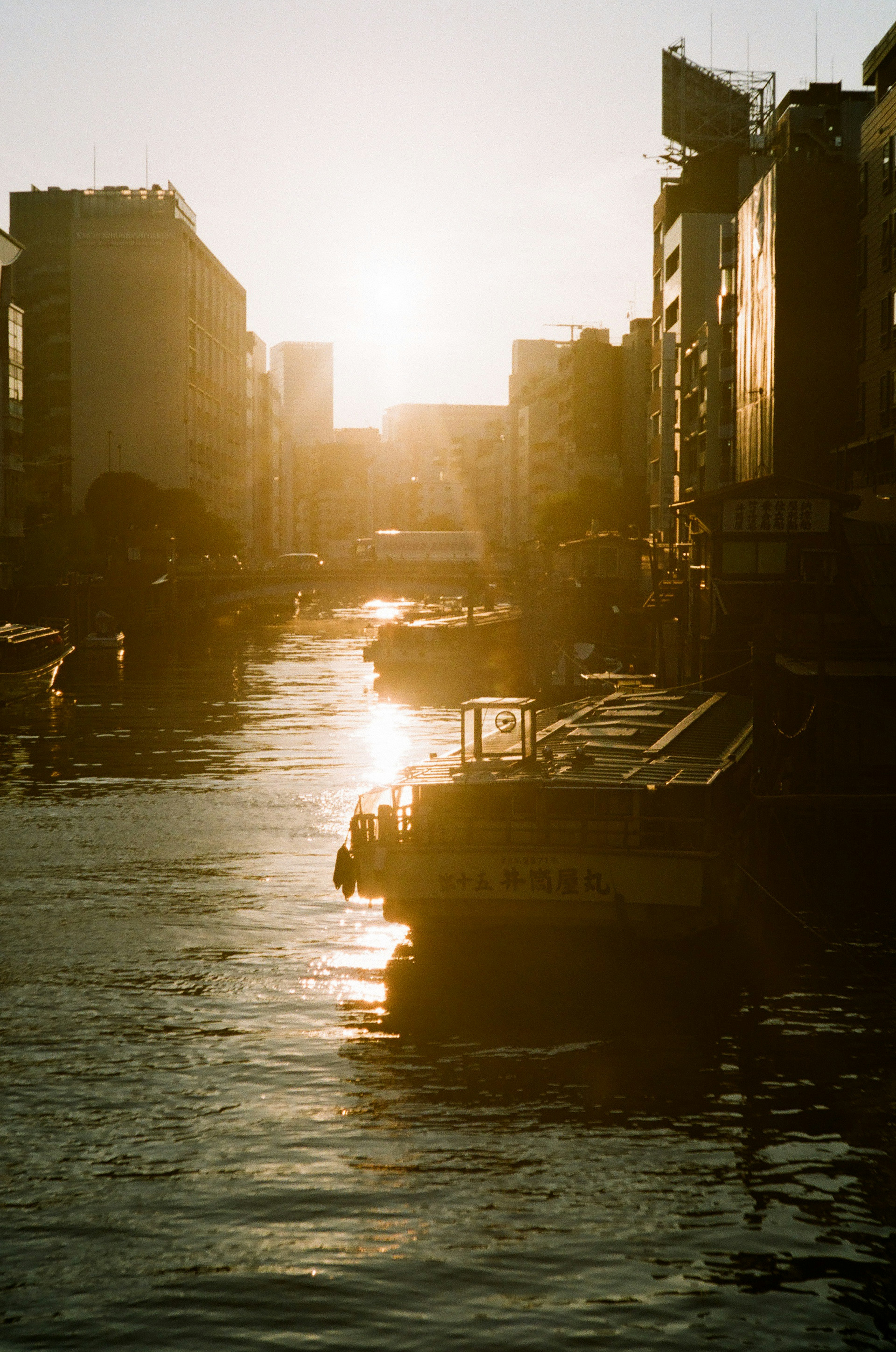 River scene with sunset reflections and buildings lining the shore