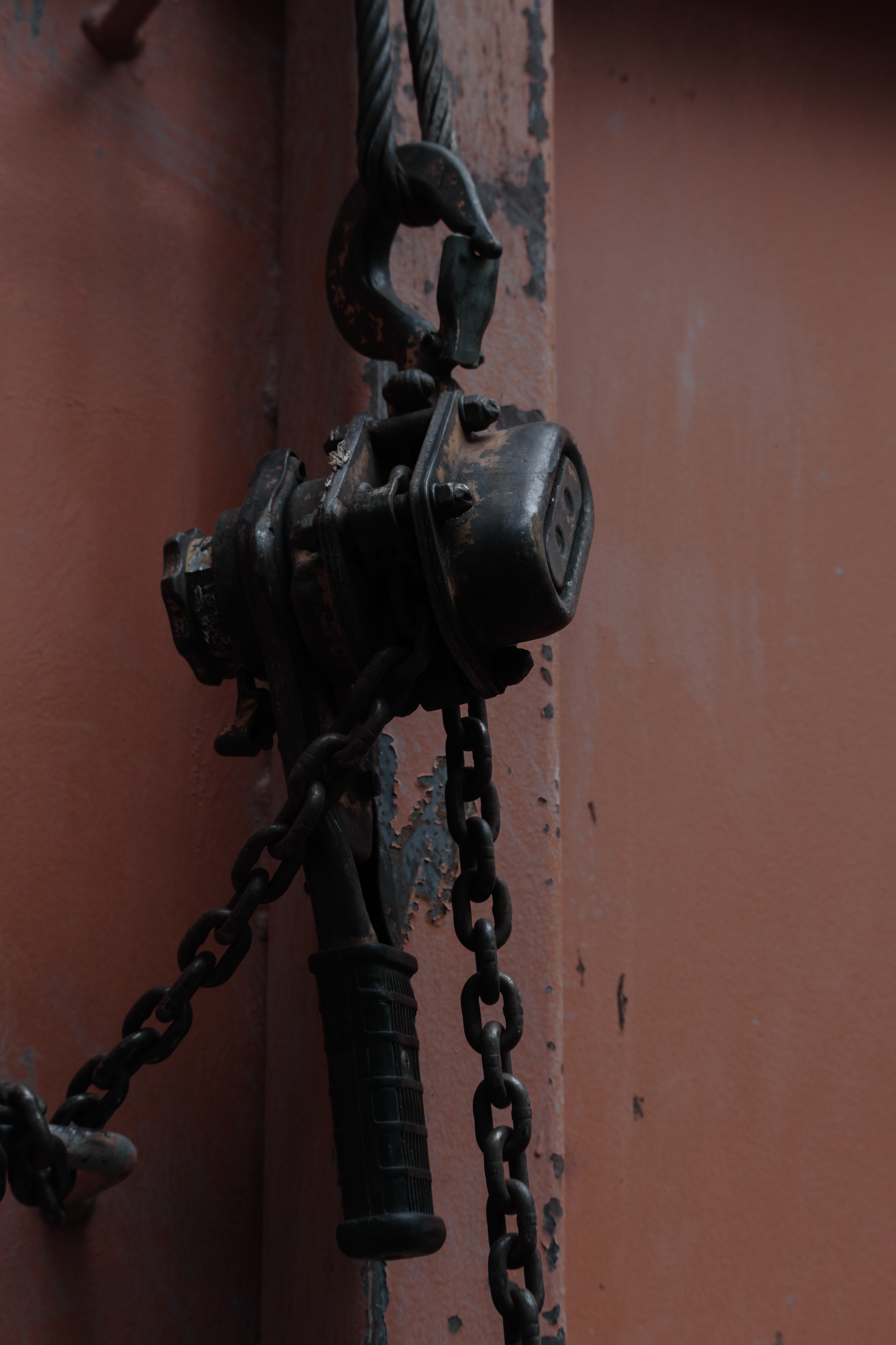 Image featuring an old chain hoist with rusty hardware