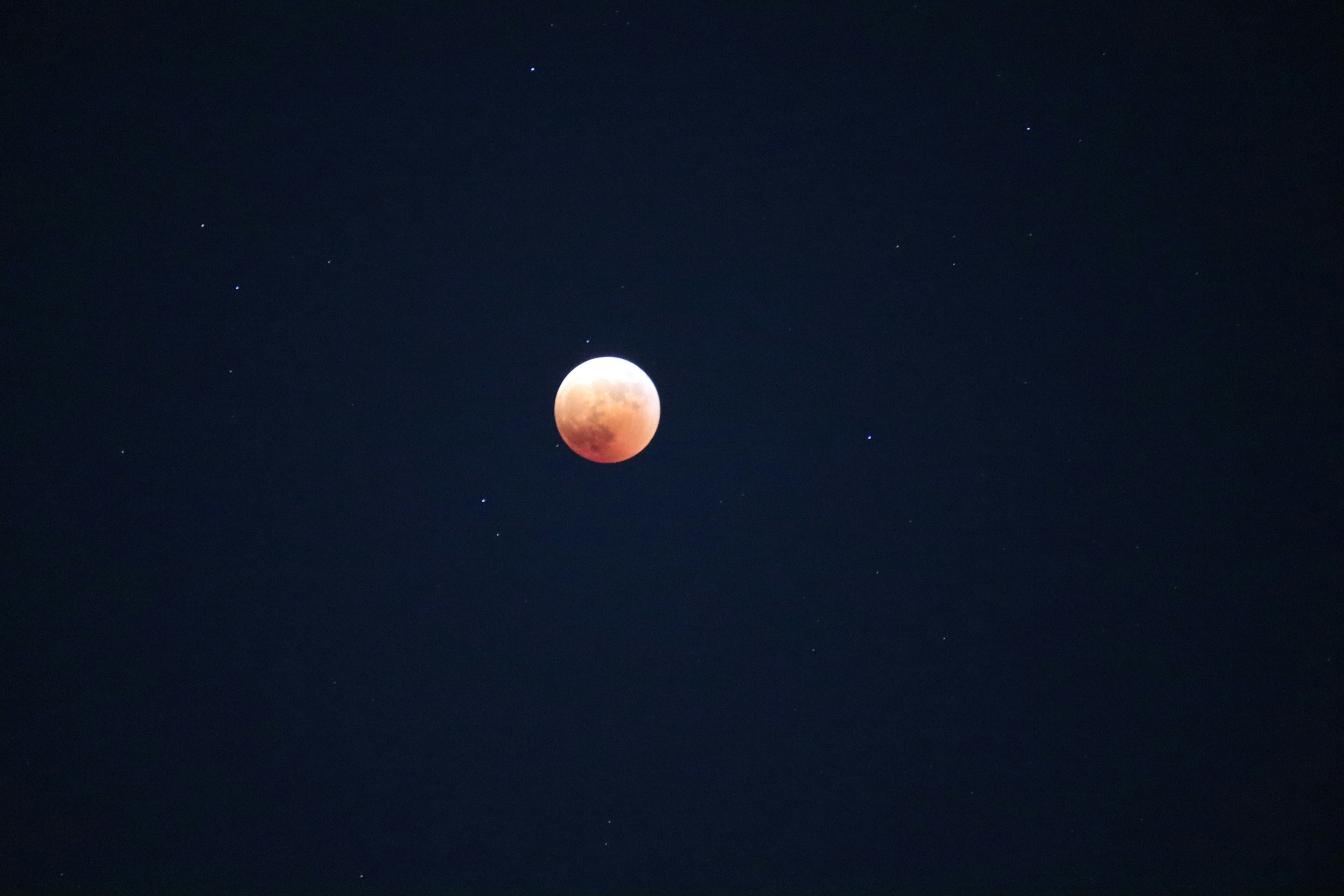 Lune rouge flottant dans un ciel nocturne sombre