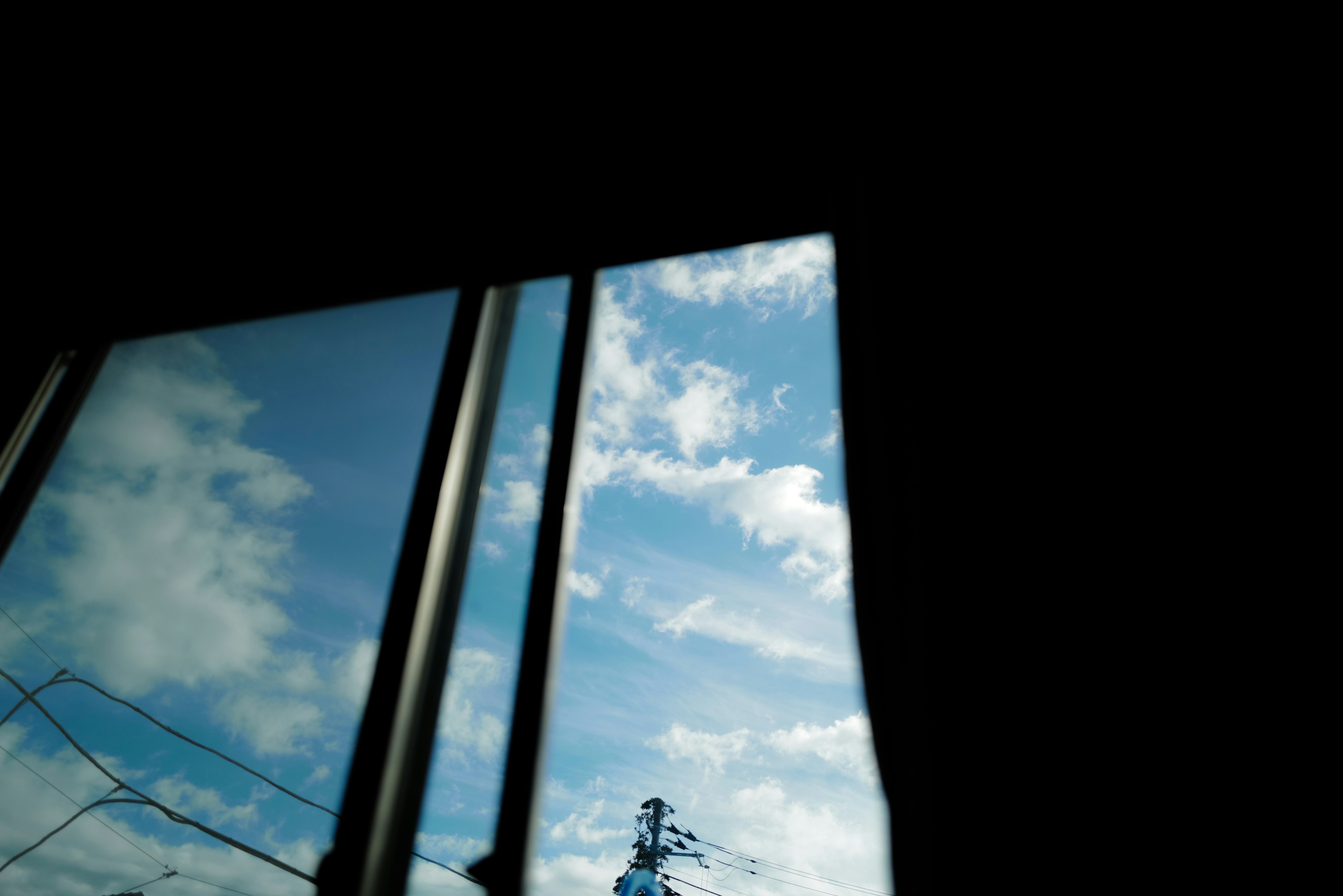 Vista del cielo azul y nubes a través de una ventana