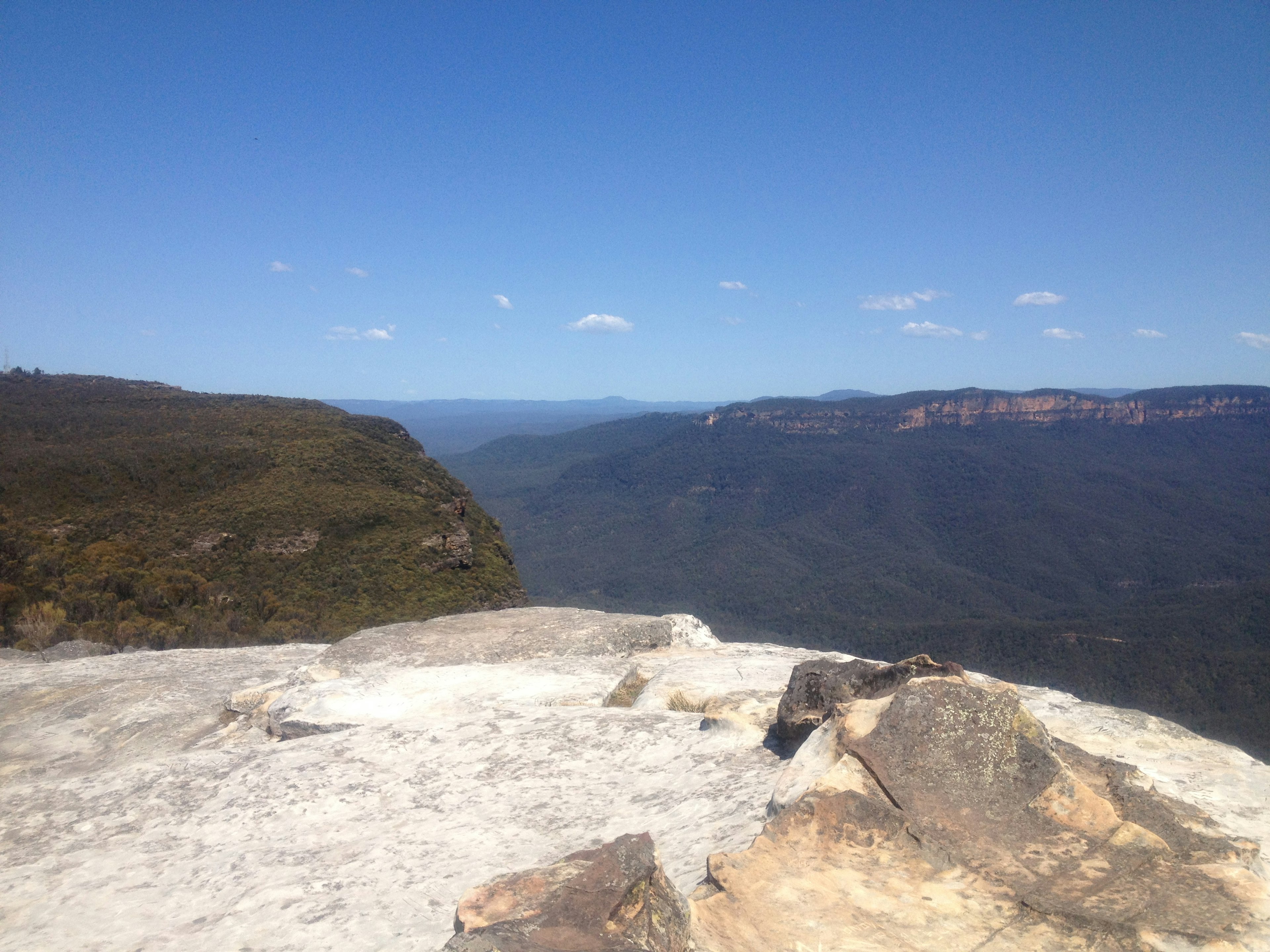 Vista panorámica desde la cima de una montaña con terreno rocoso y colinas distantes