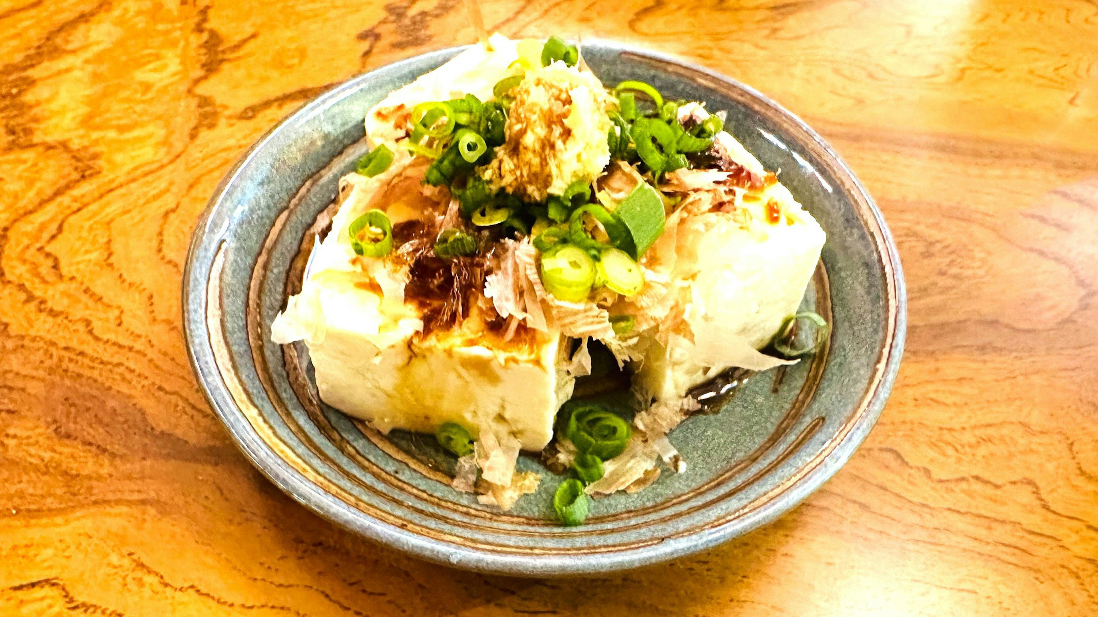 Tofu a la parrilla cubierto con cebollas verdes y jengibre