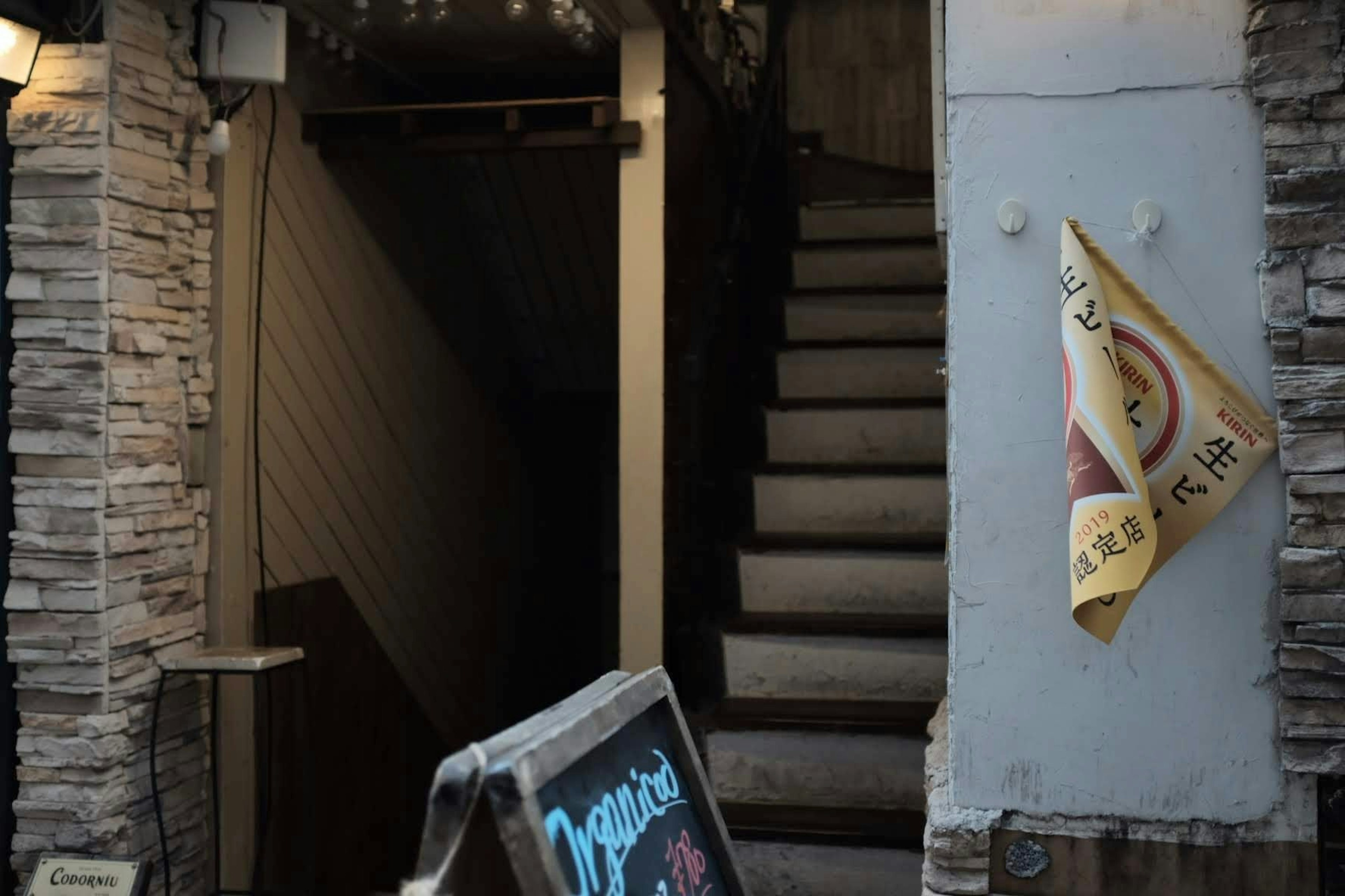 Entrée avec escaliers et mur en pierre un panneau placé à l'extérieur