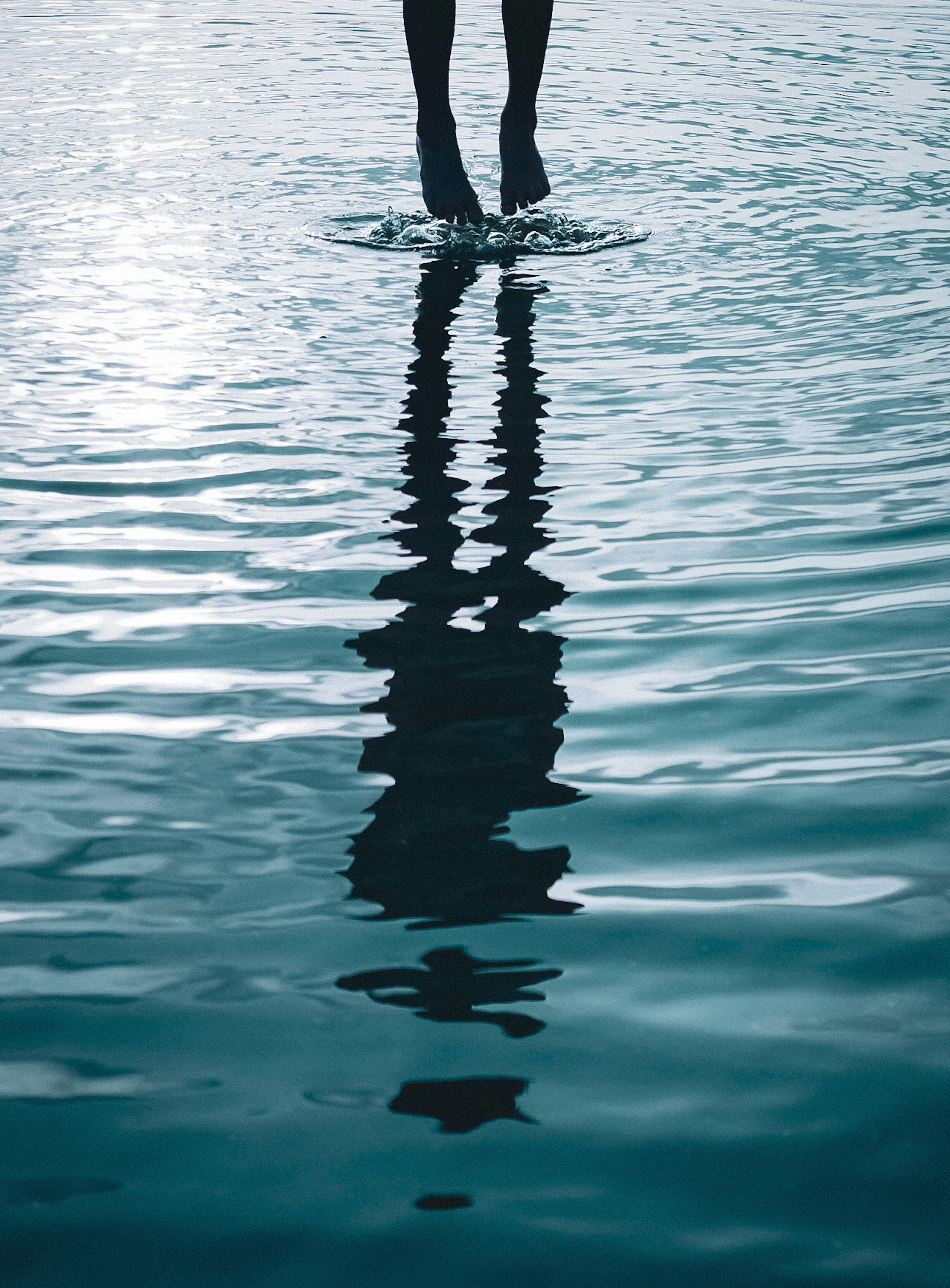 A silhouette of a person standing on the water surface