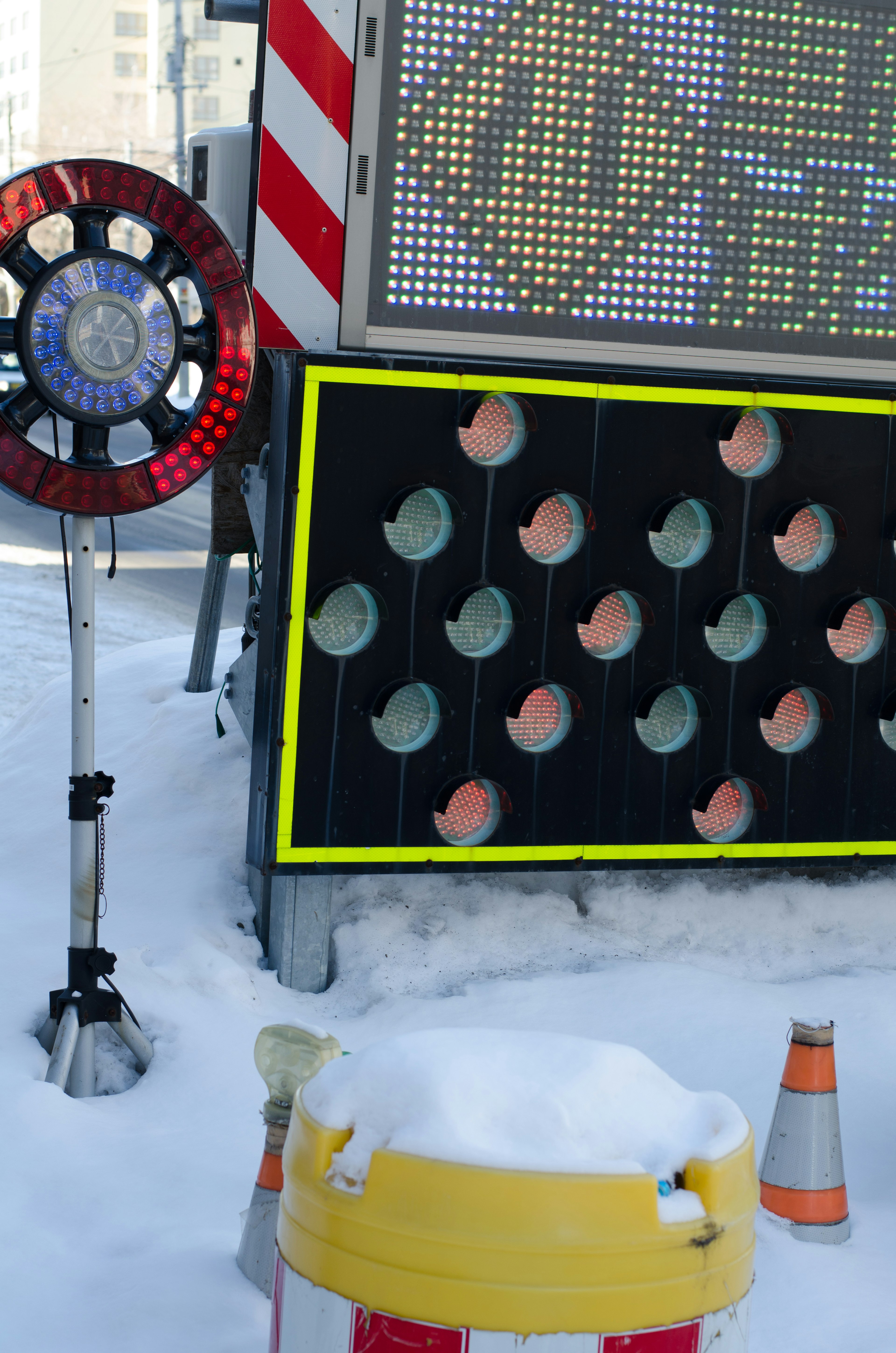 Image of a snow-covered road construction sign and traffic lights