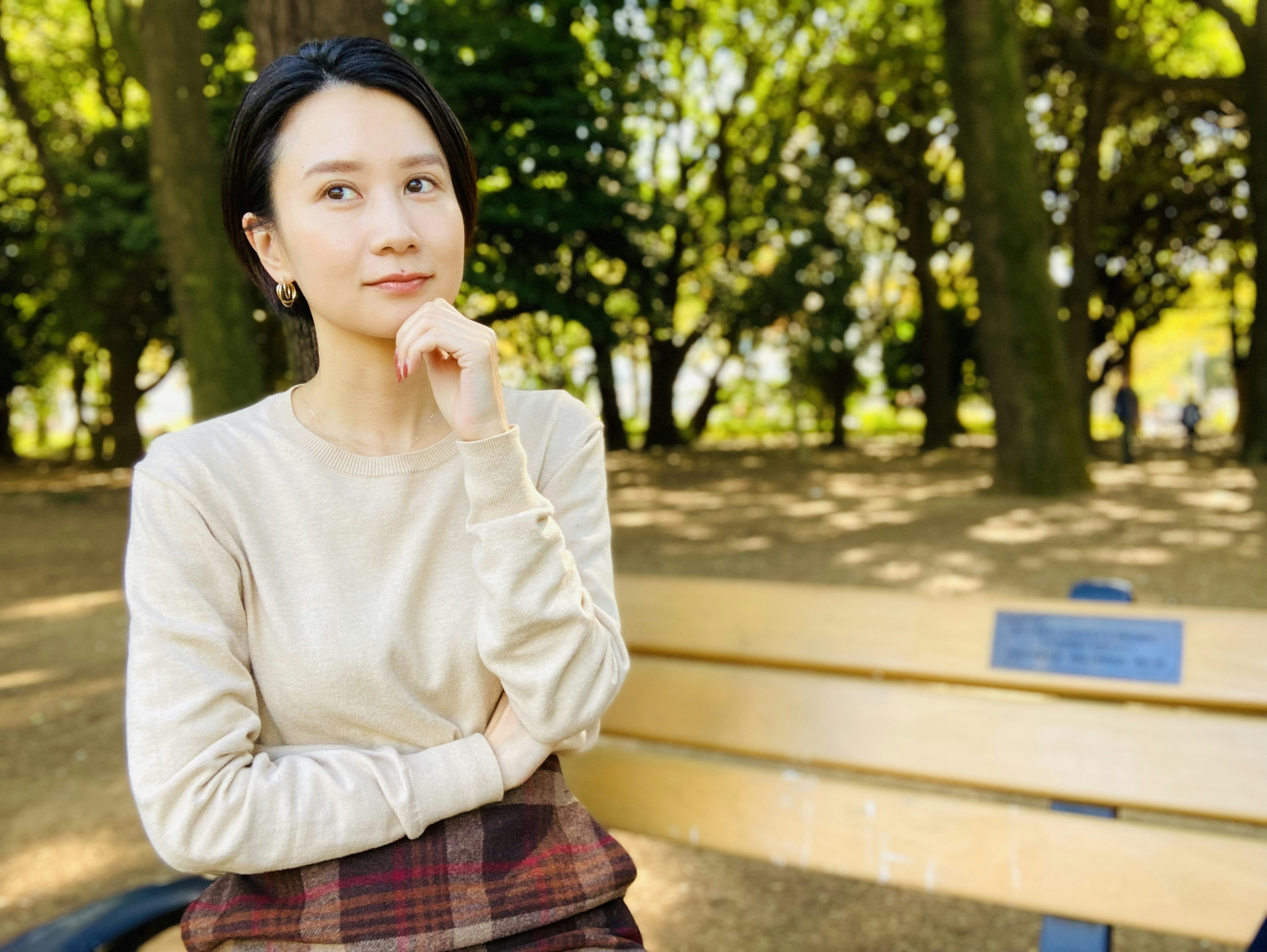 Une femme assise sur un banc de parc en pleine réflexion