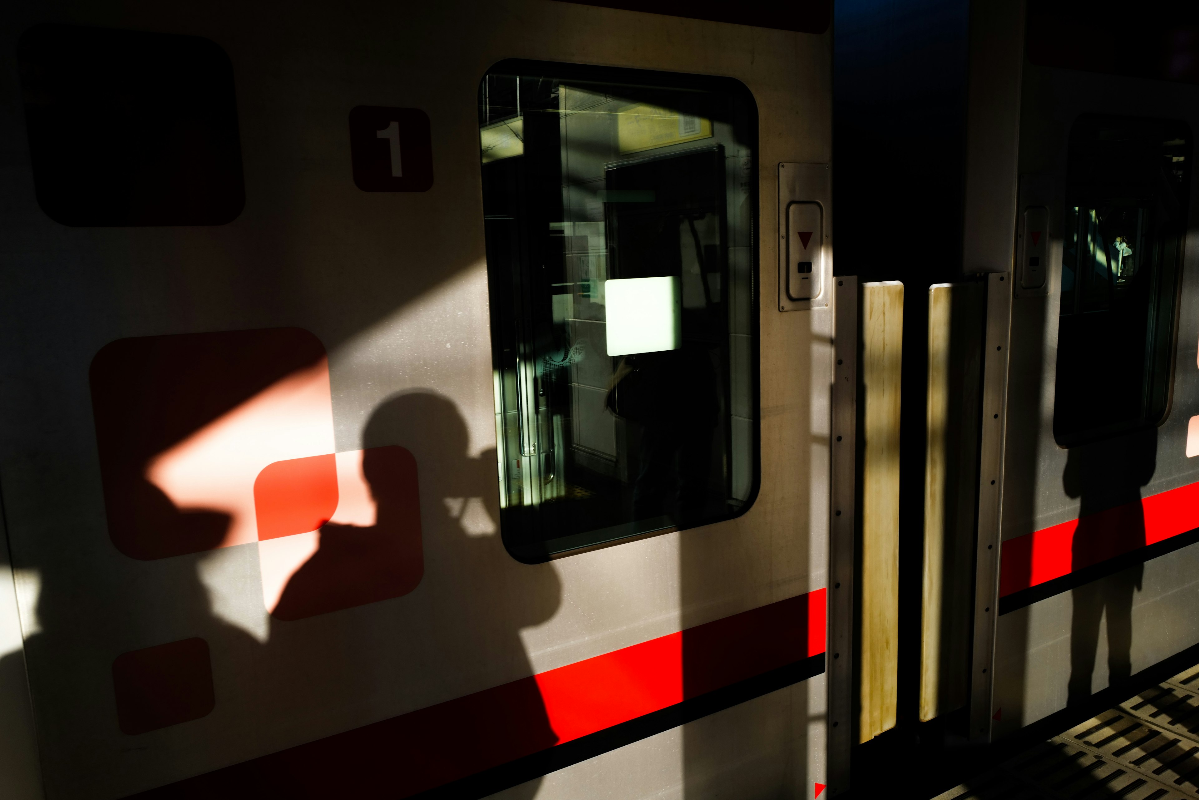 A train at a station with shadows and sunlight