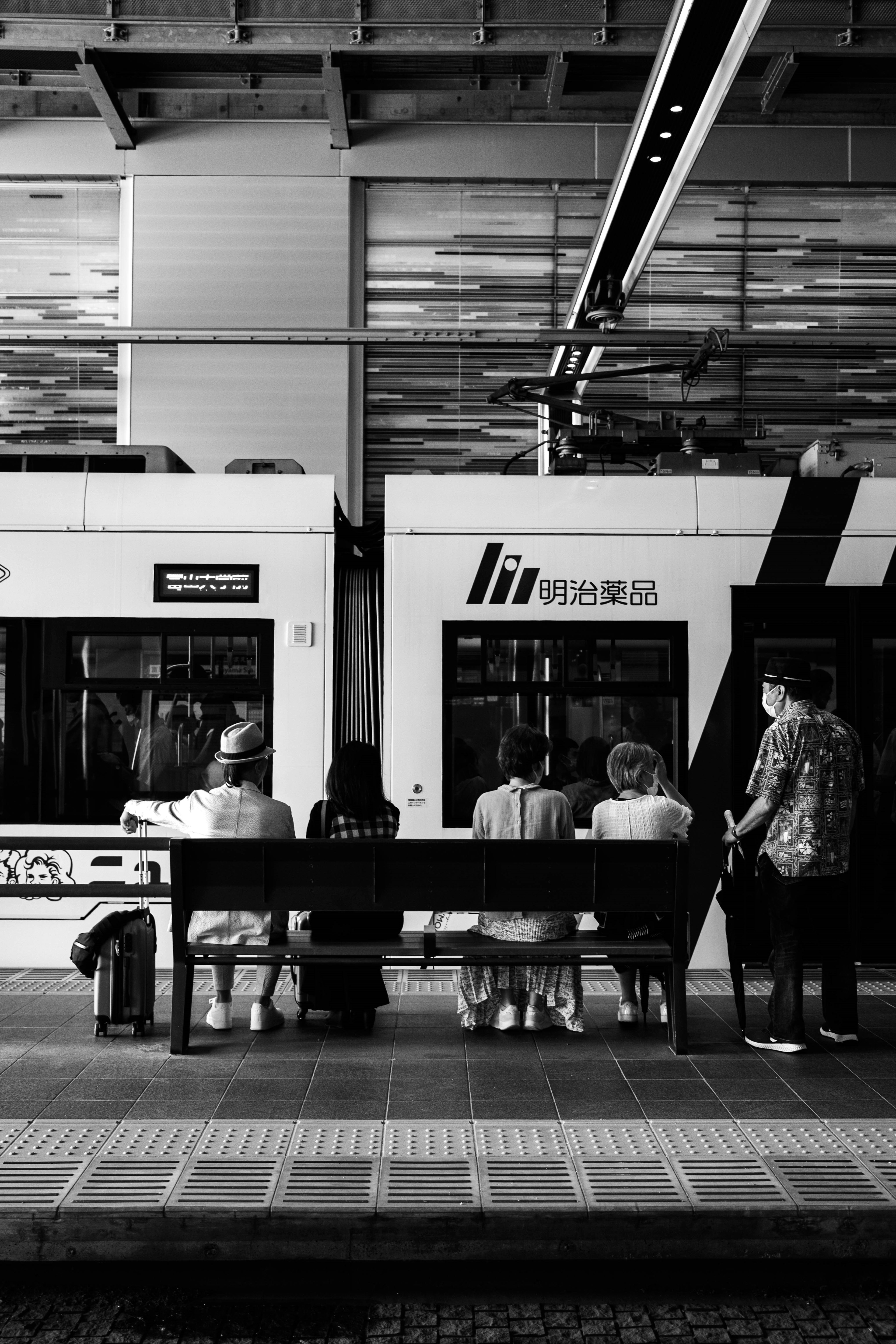 Black and white photo of people waiting on a train platform