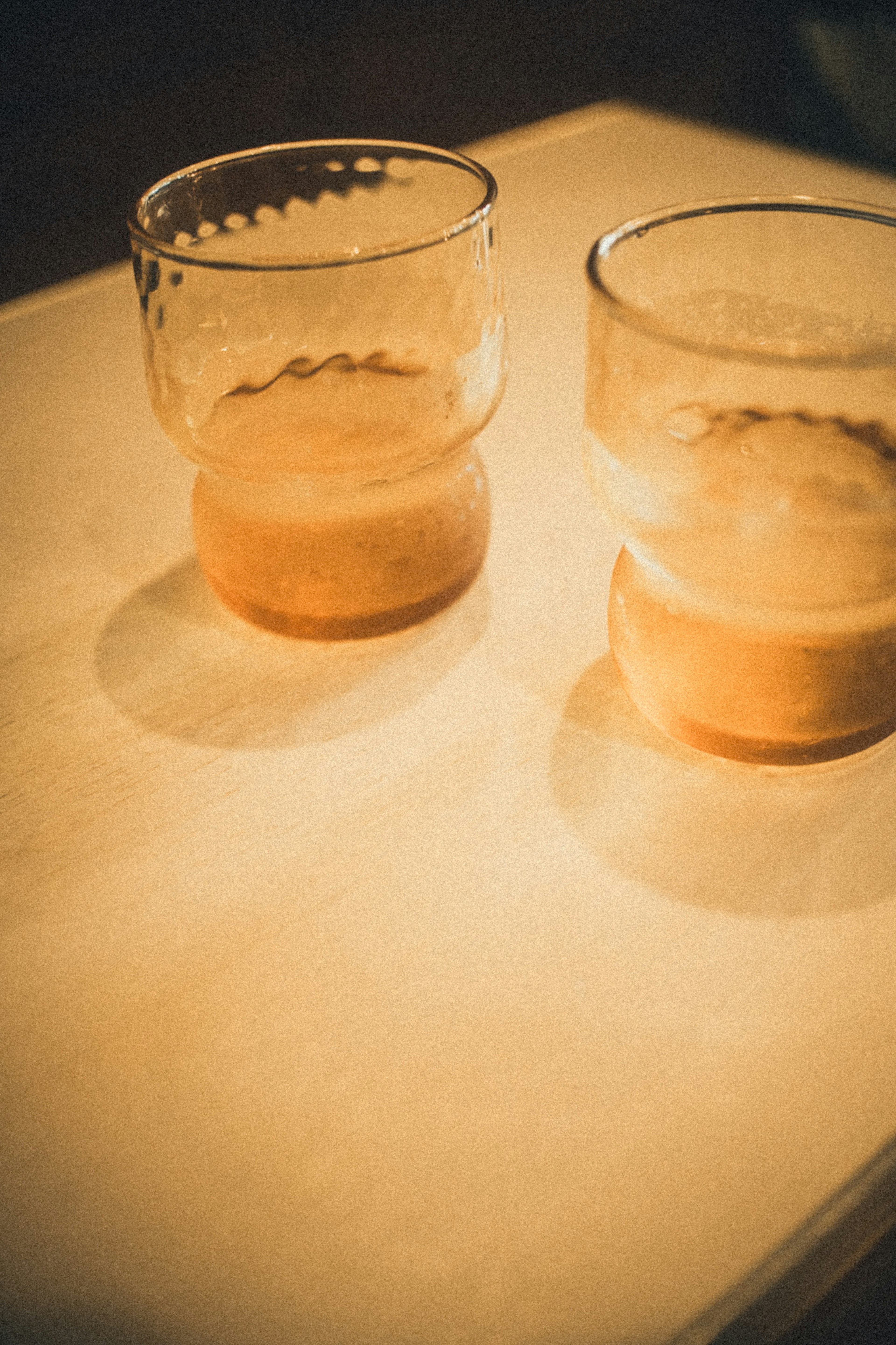 Two glasses with drinks placed on a table