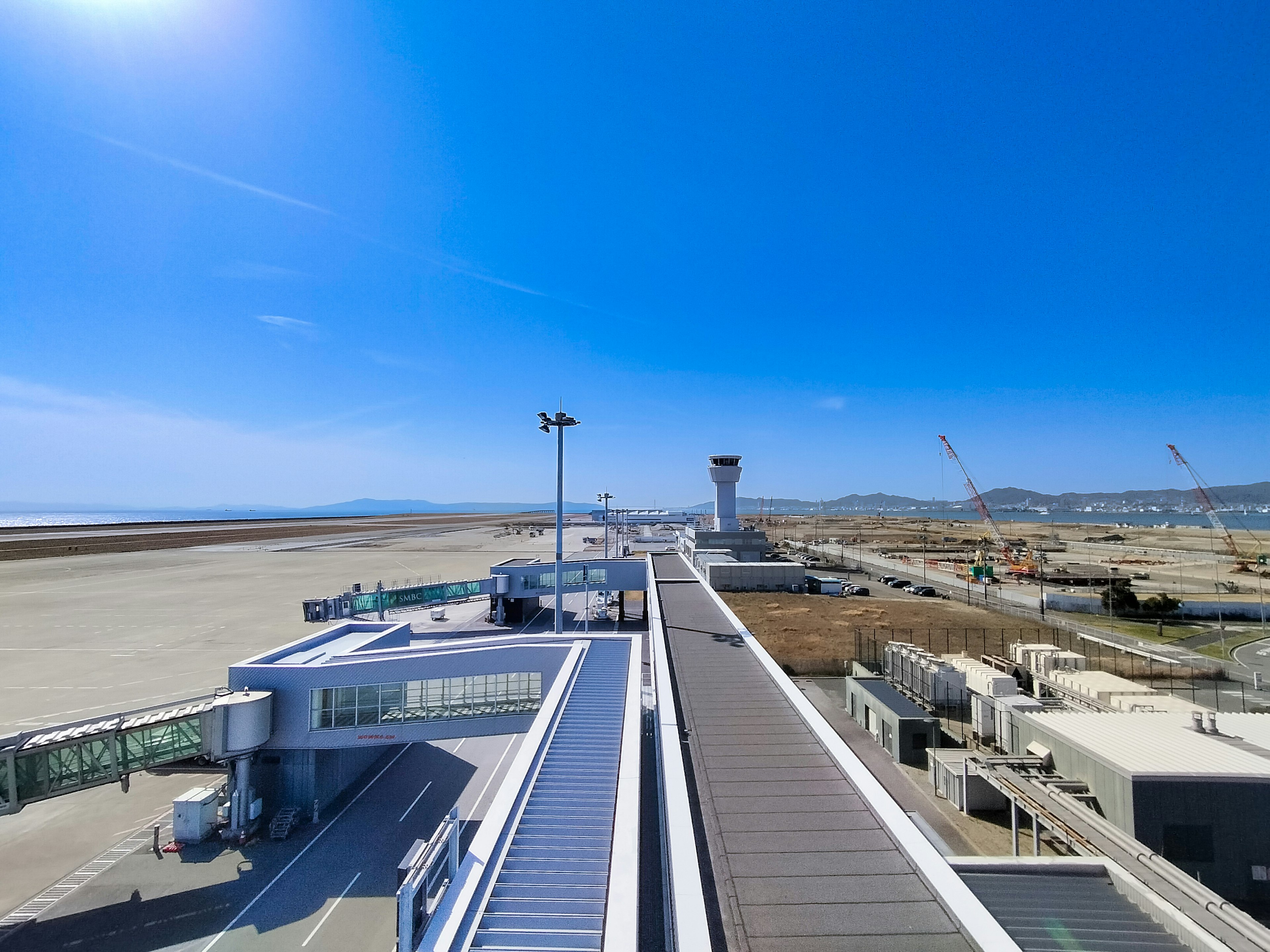 View of an airport runway and terminal under a clear blue sky