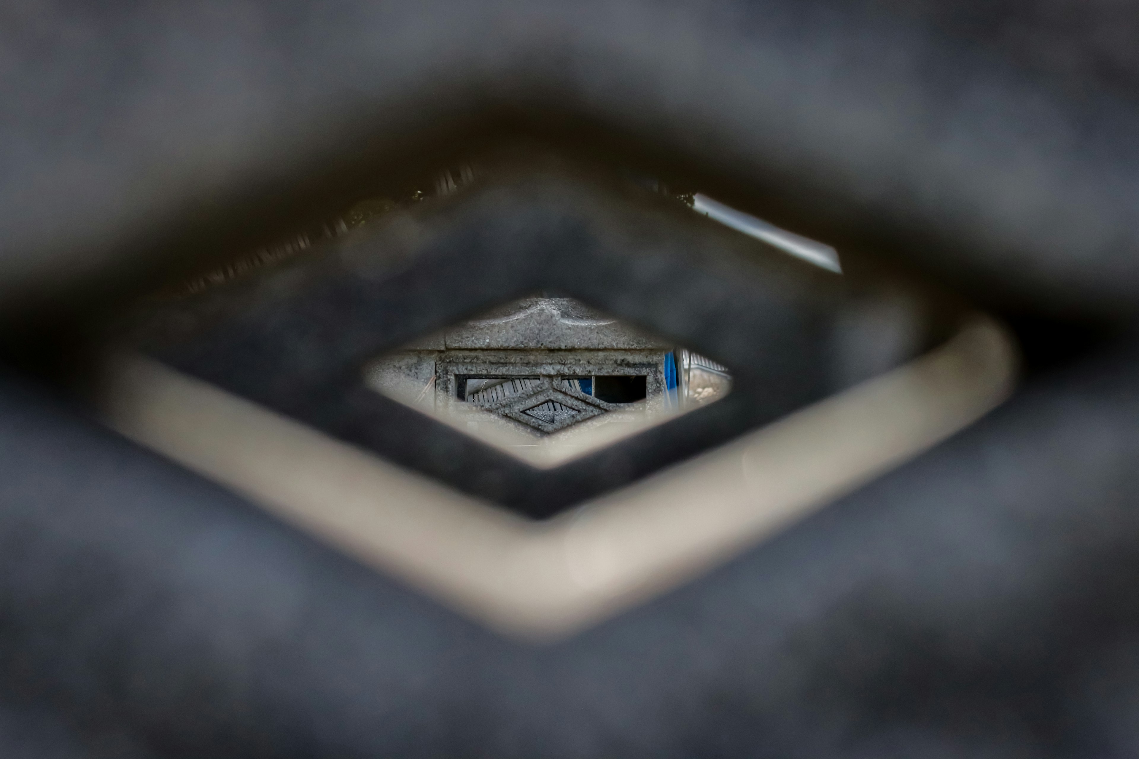 A view through a diamond-shaped opening revealing details of an object