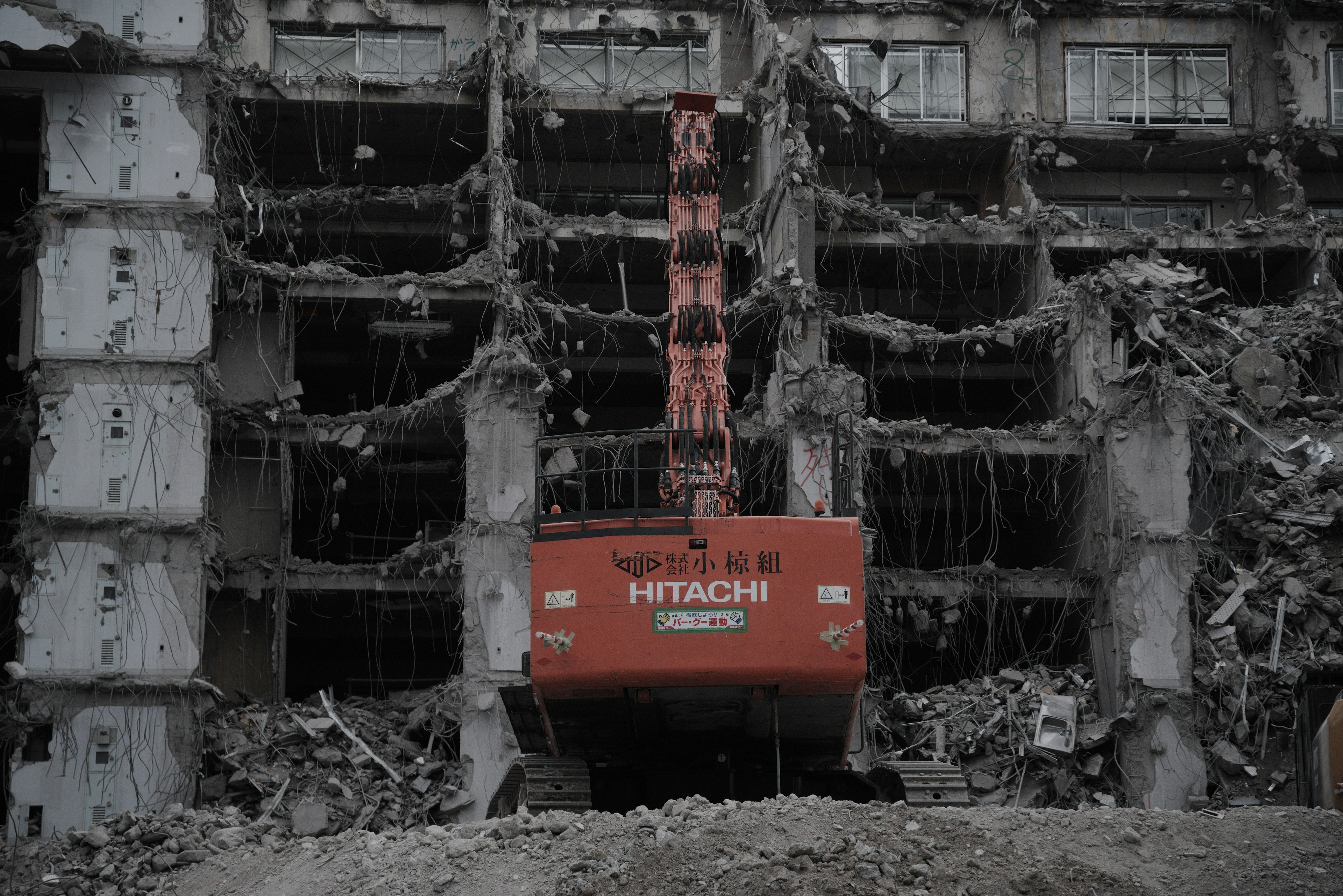 Red Hitachi excavator at a building demolition site