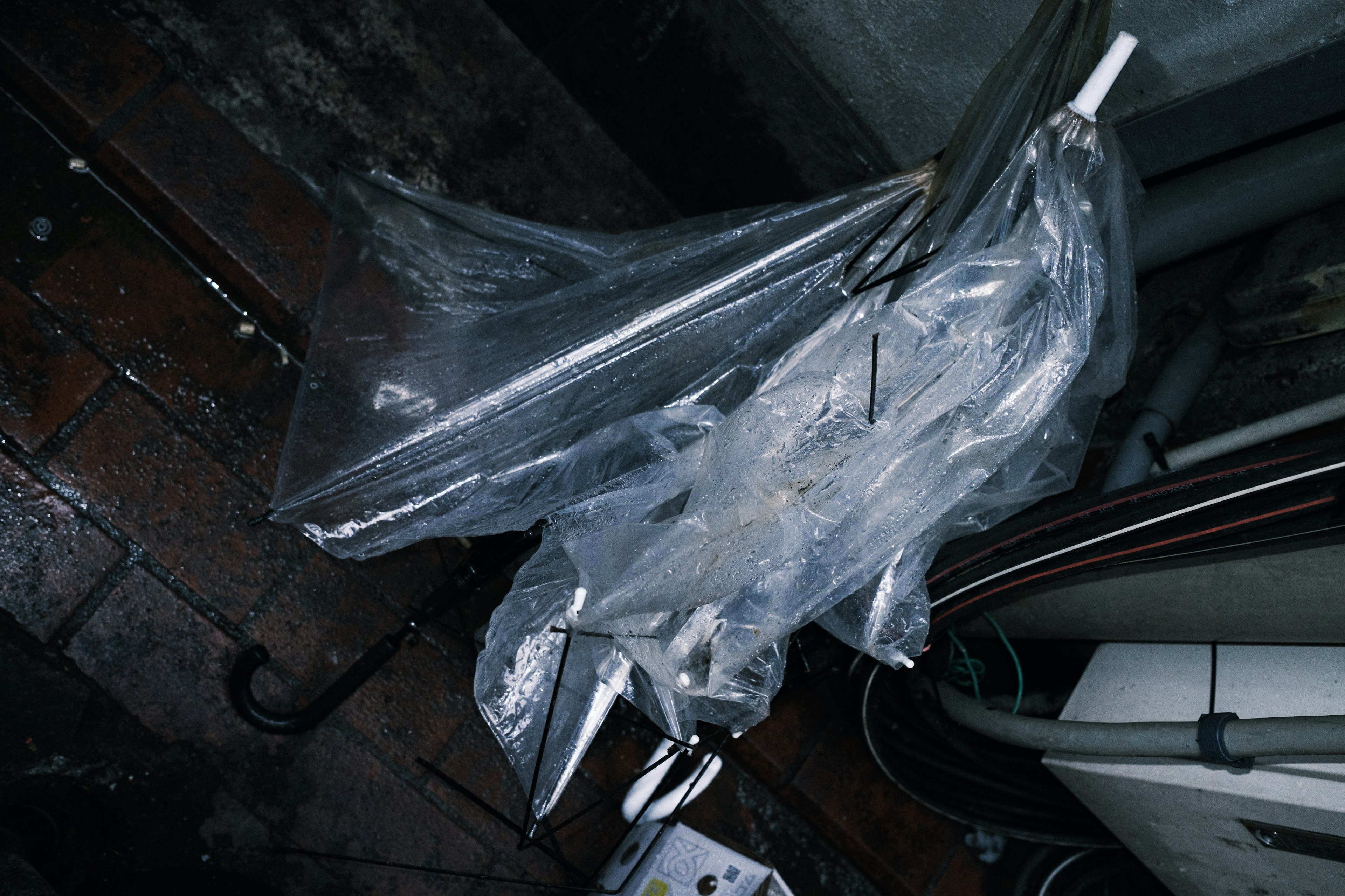 A wet umbrella covered with transparent plastic