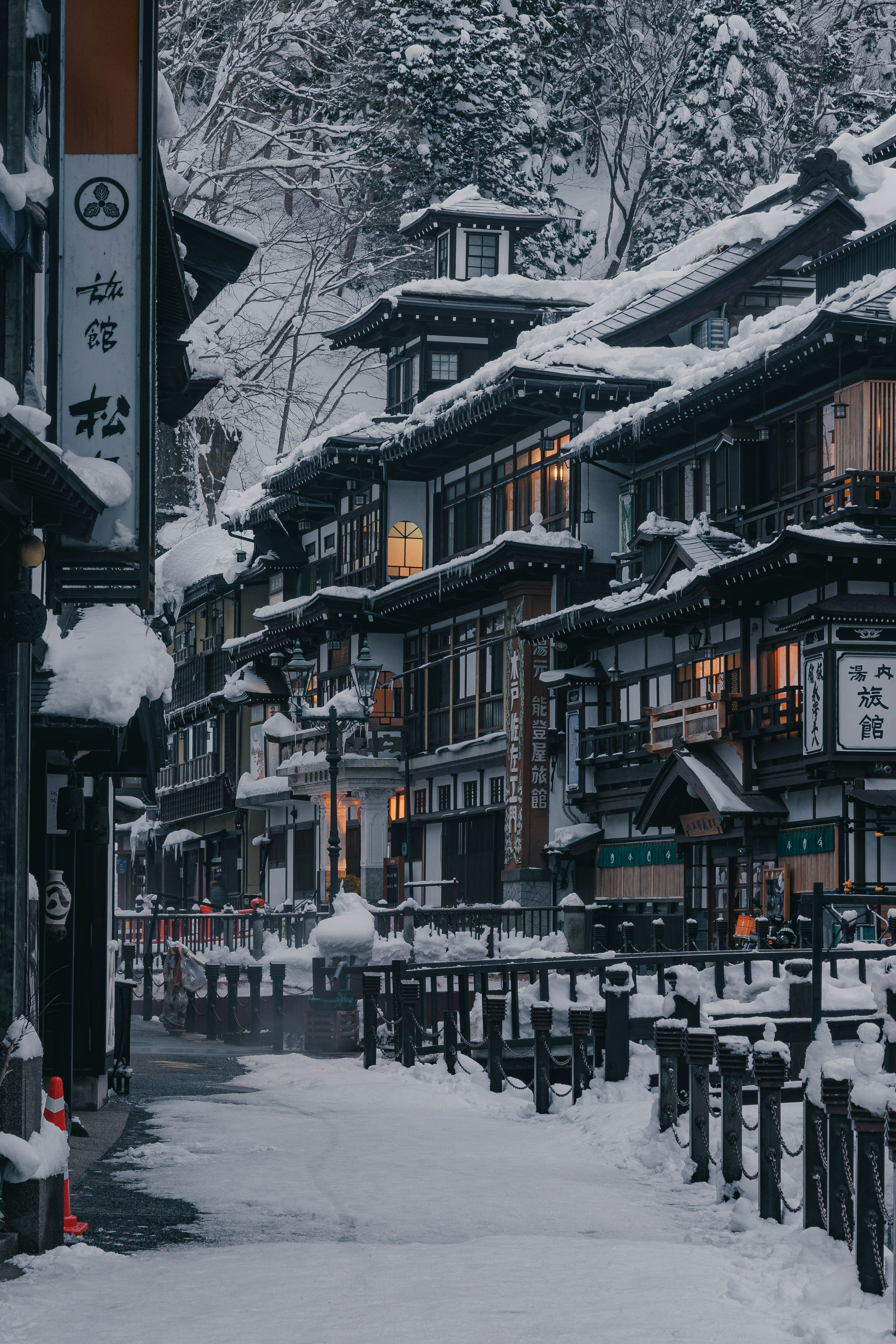 Snow-covered hot spring town scene with traditional buildings