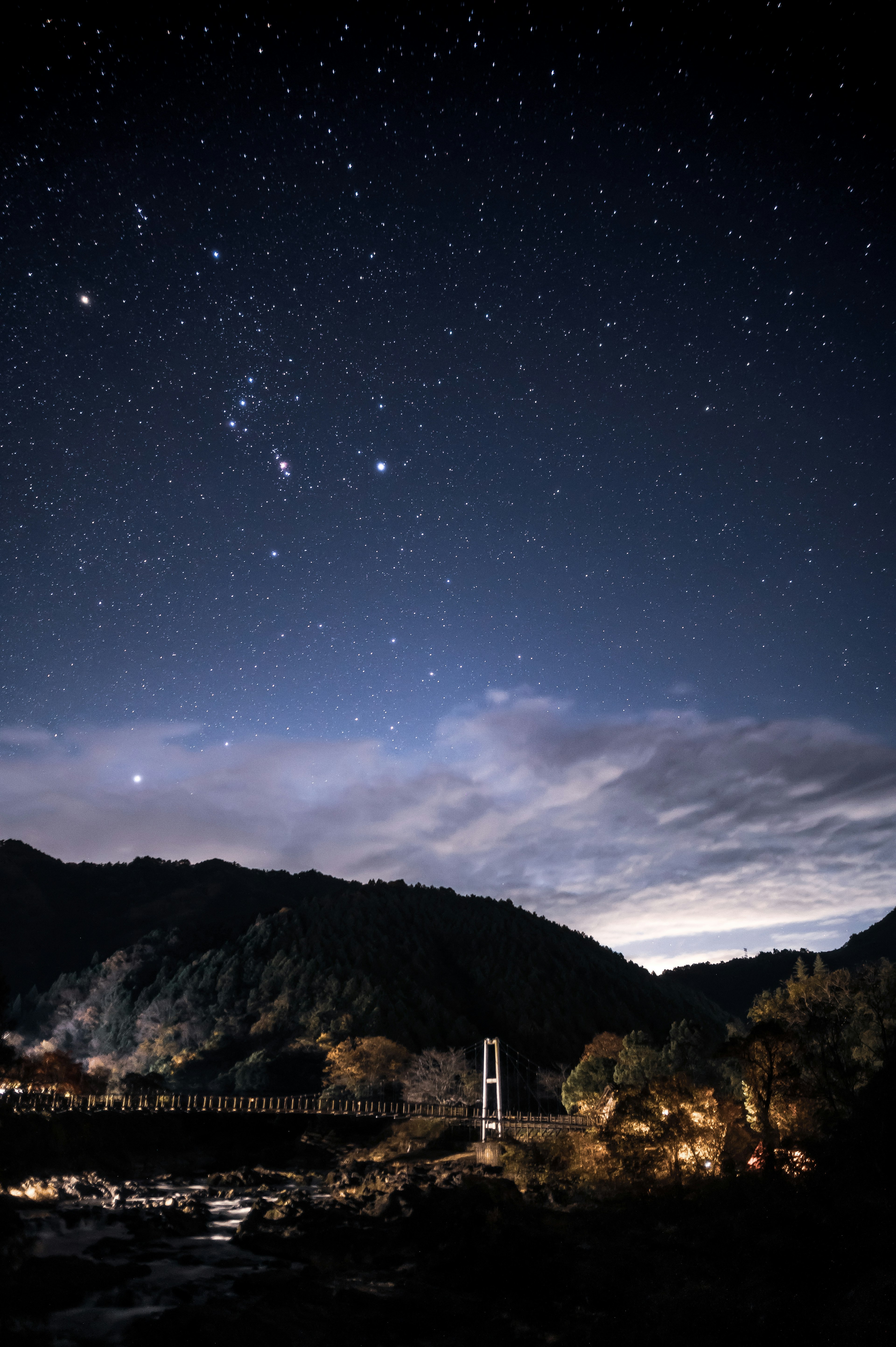 星空と山々の風景 夜空に輝く星々と雲が広がる