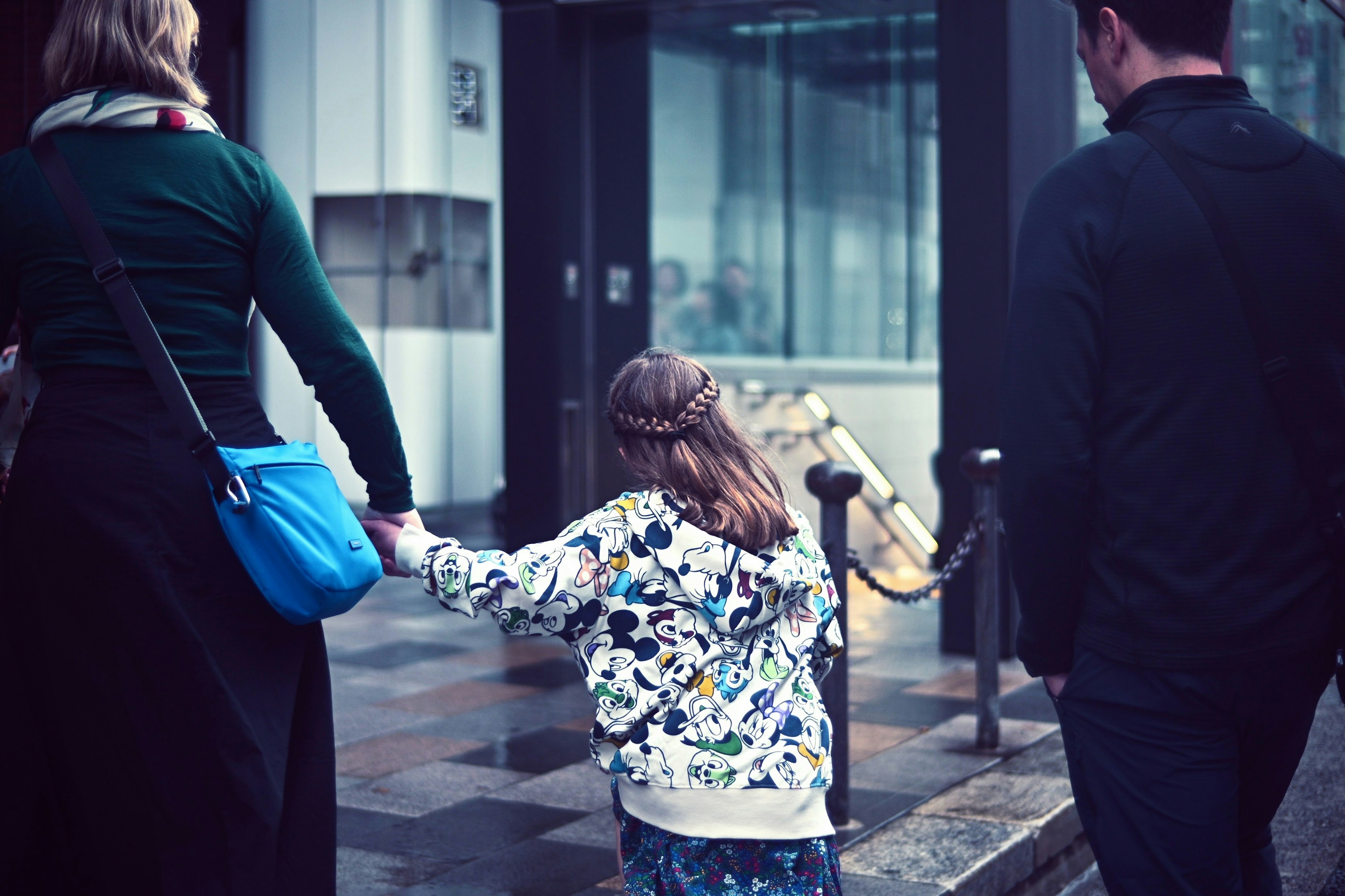 Una famiglia che cammina mano nella mano in un ambiente urbano