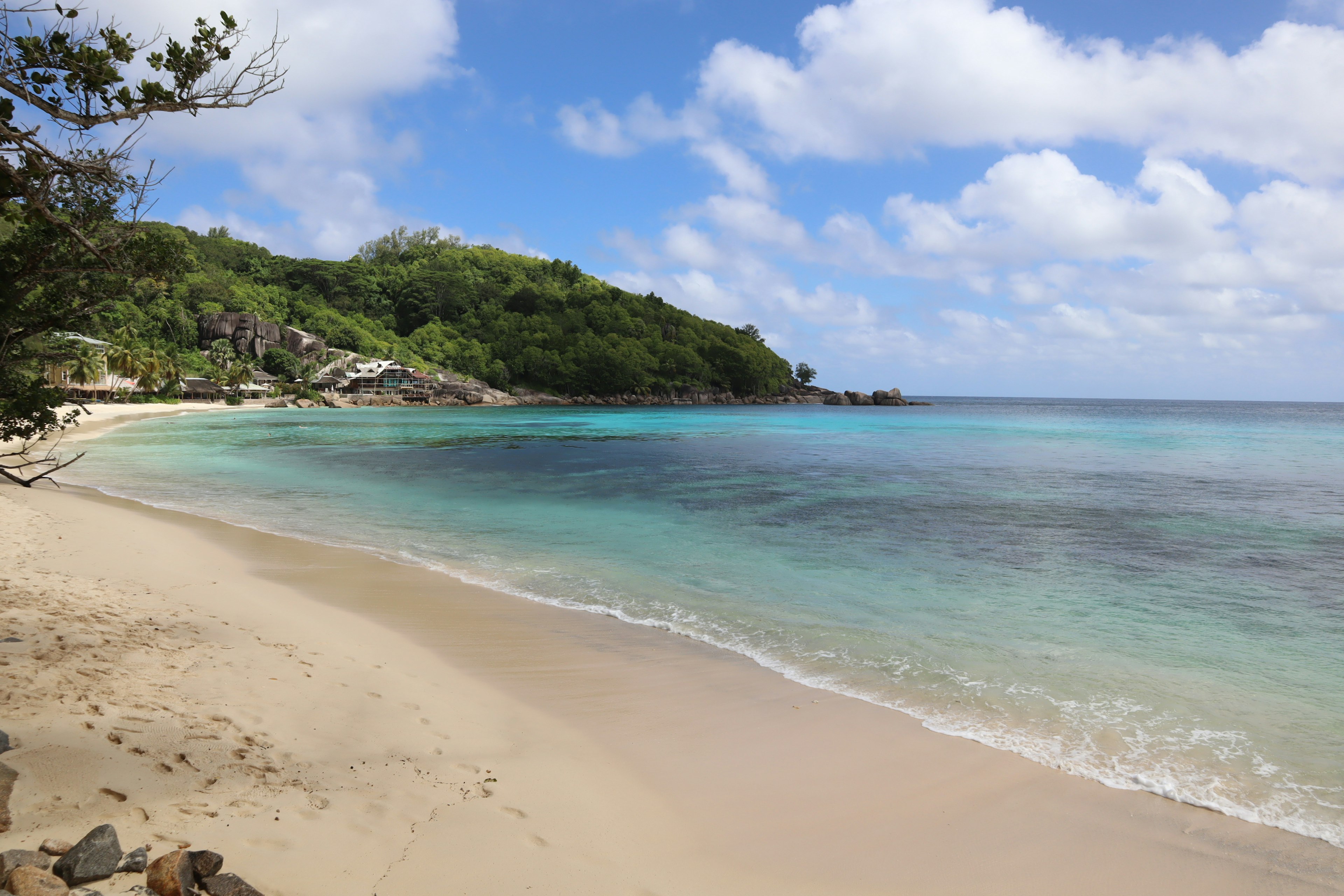 ทิวทัศน์ชายหาดเขตร้อนกับทะเลสีน้ำเงินและทรายขาว