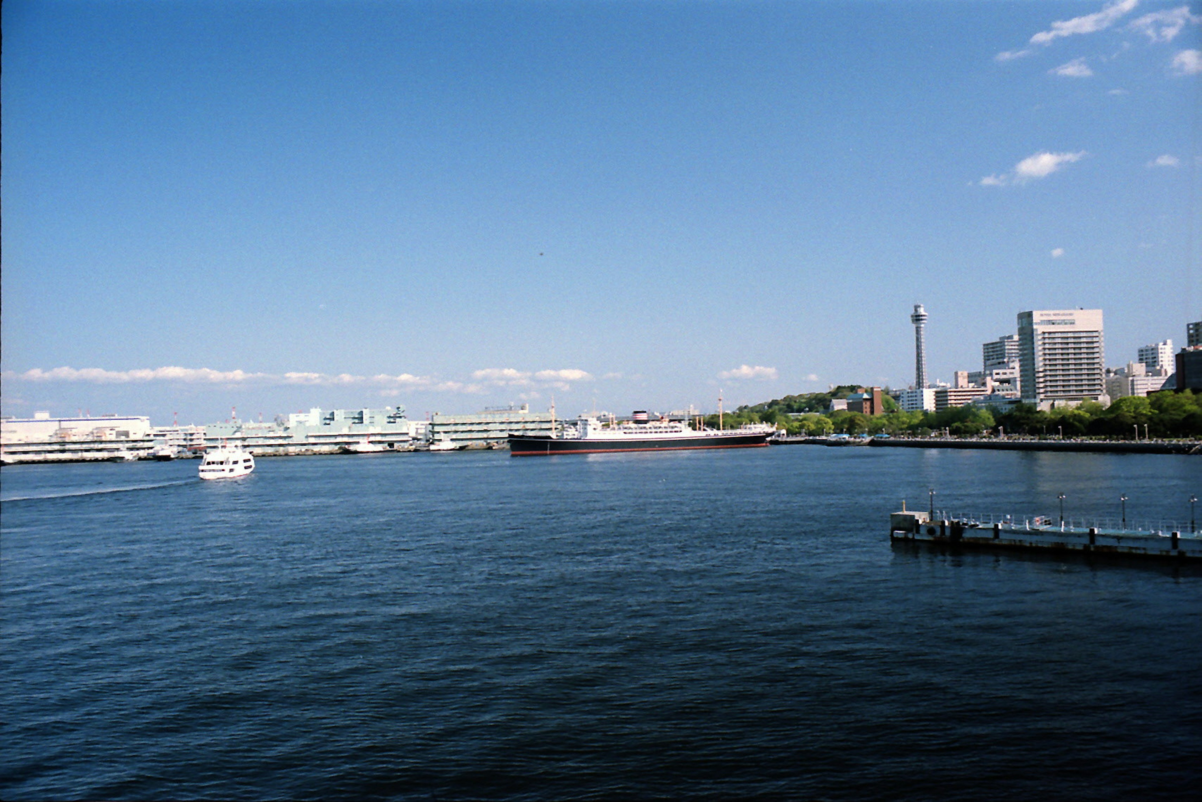 Scenic view of a blue sky and calm water with boats