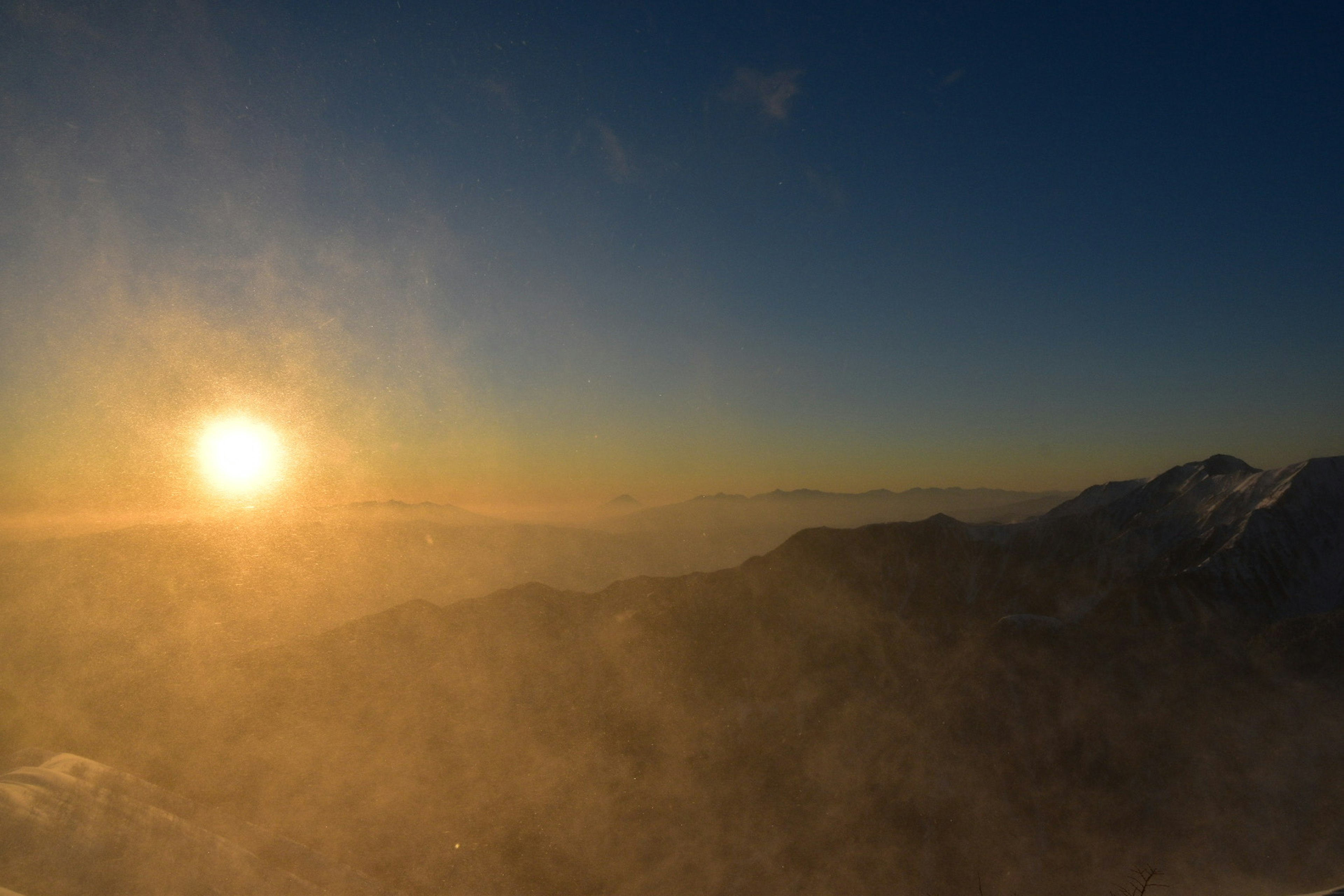 Vue magnifique du soleil se levant sur des montagnes brumeuses