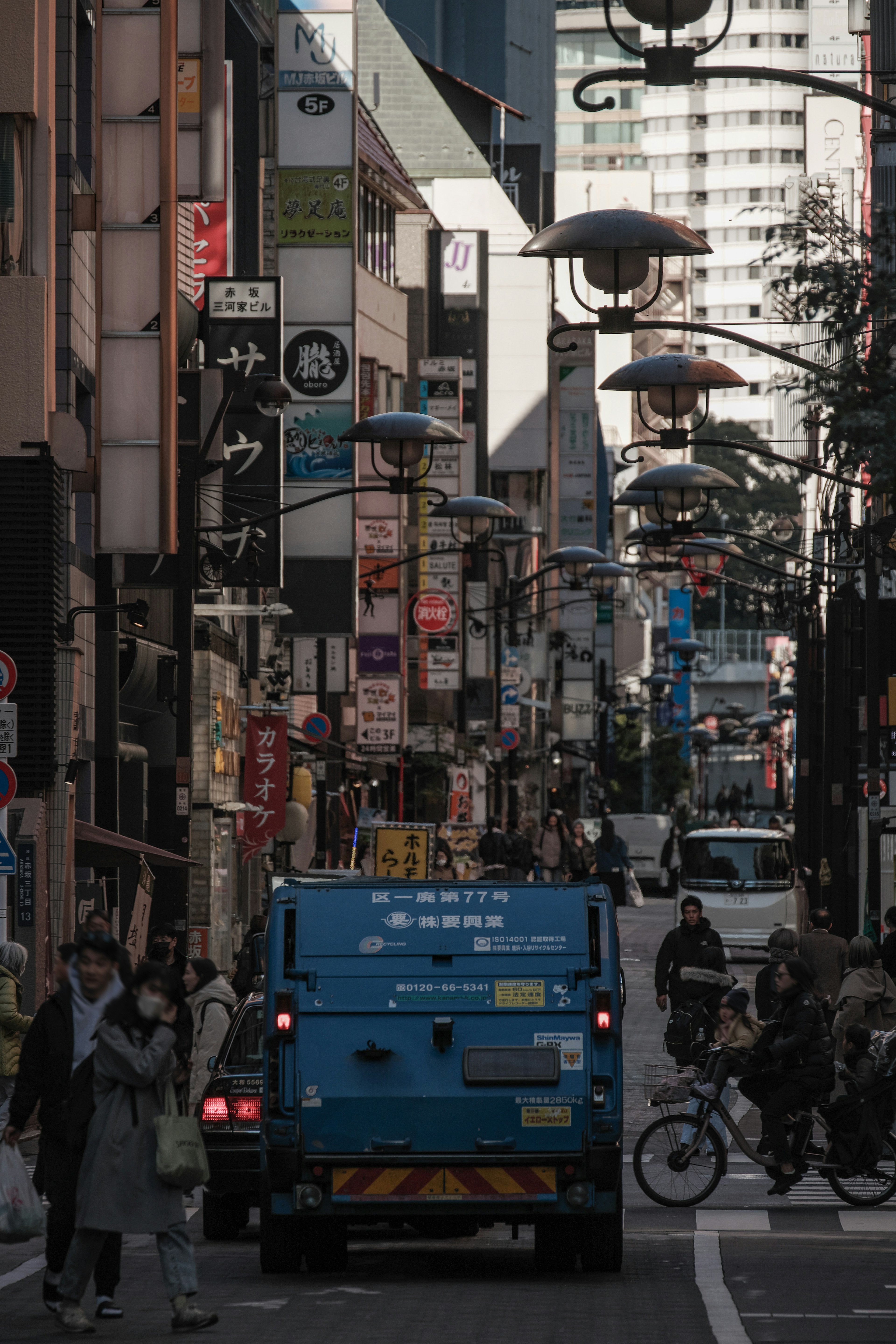 A vibrant street scene featuring a blue vehicle and pedestrians