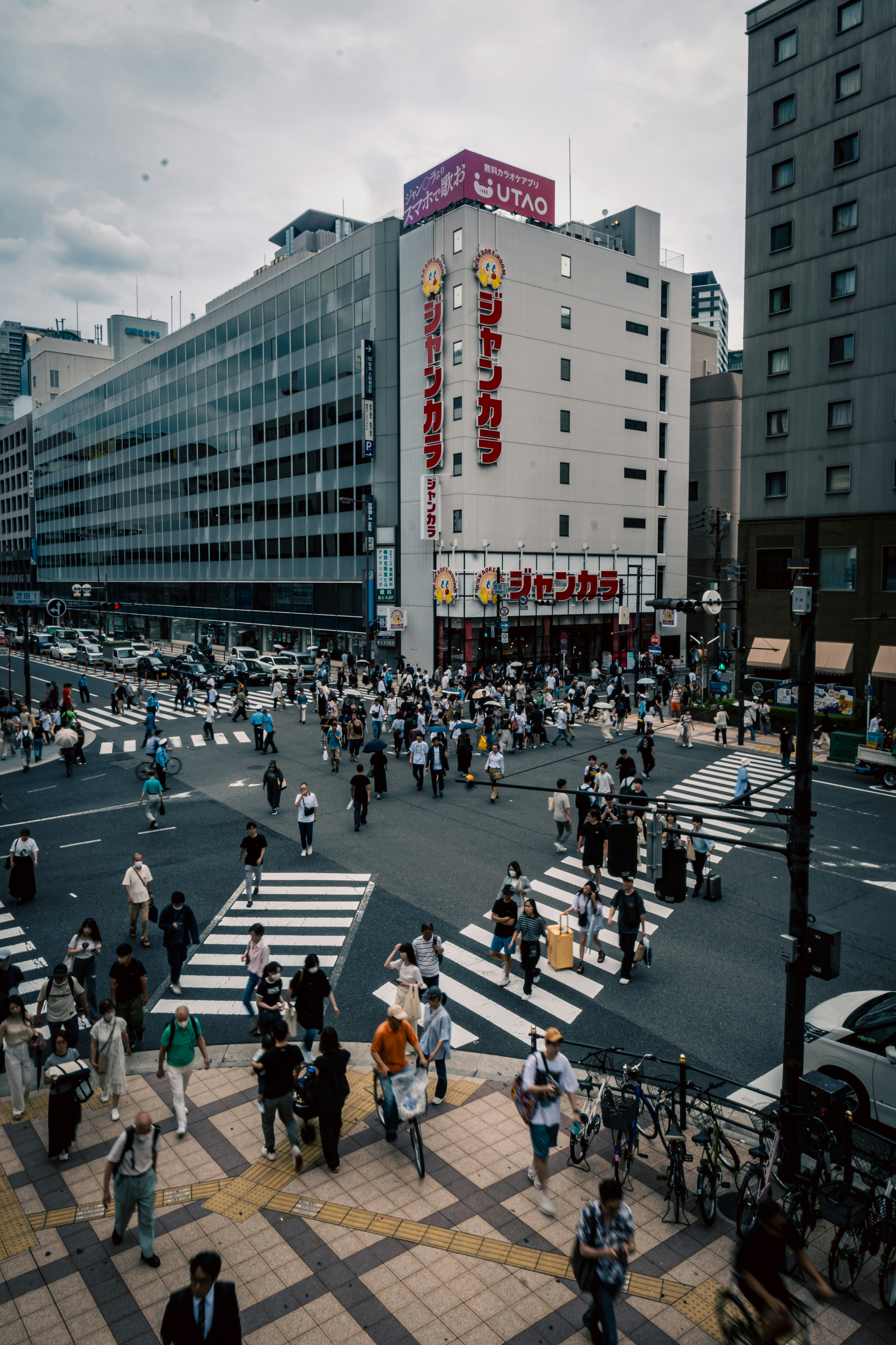 A bustling intersection with crowds of pedestrians and high-rise buildings