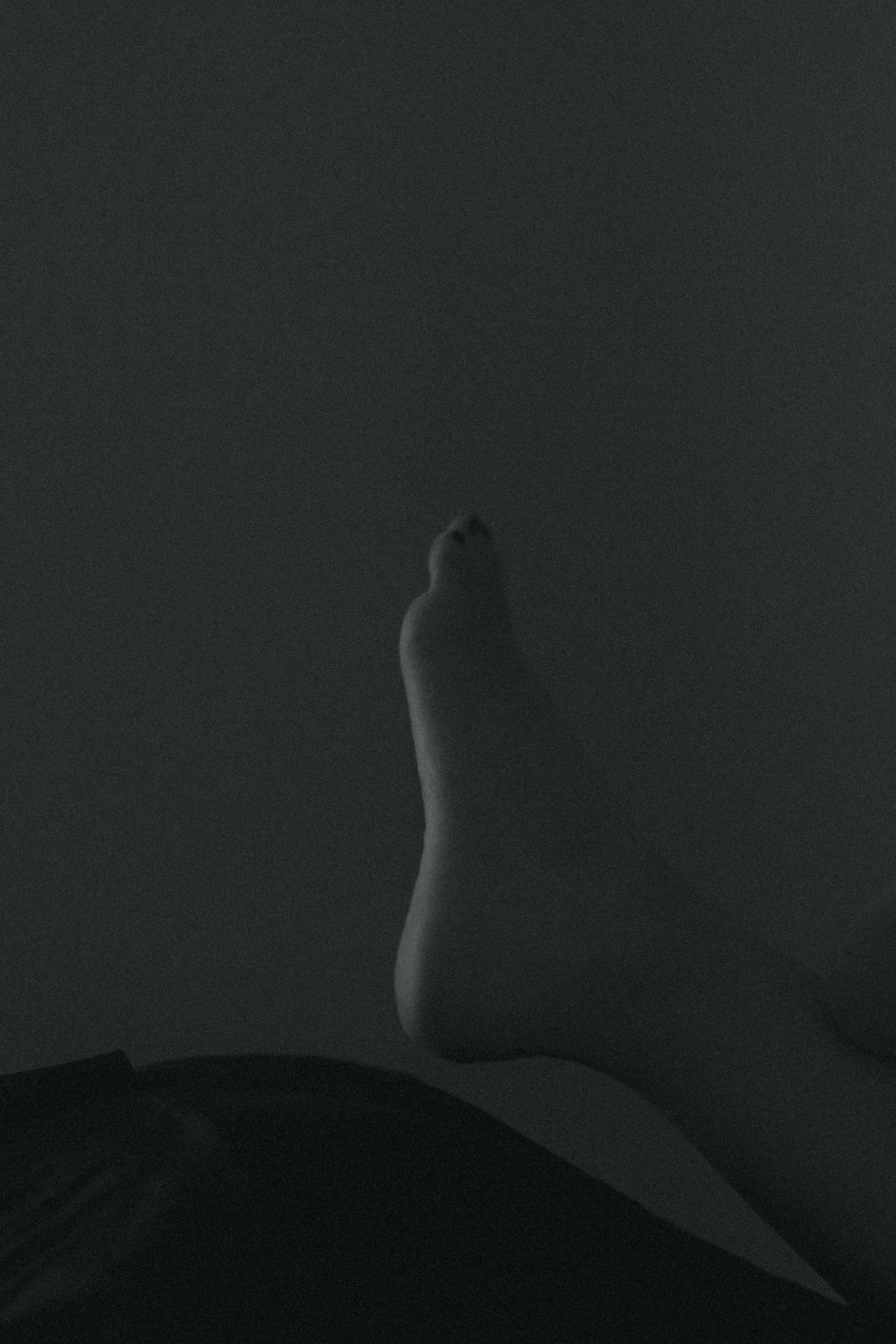 A foot partially visible against a dark background