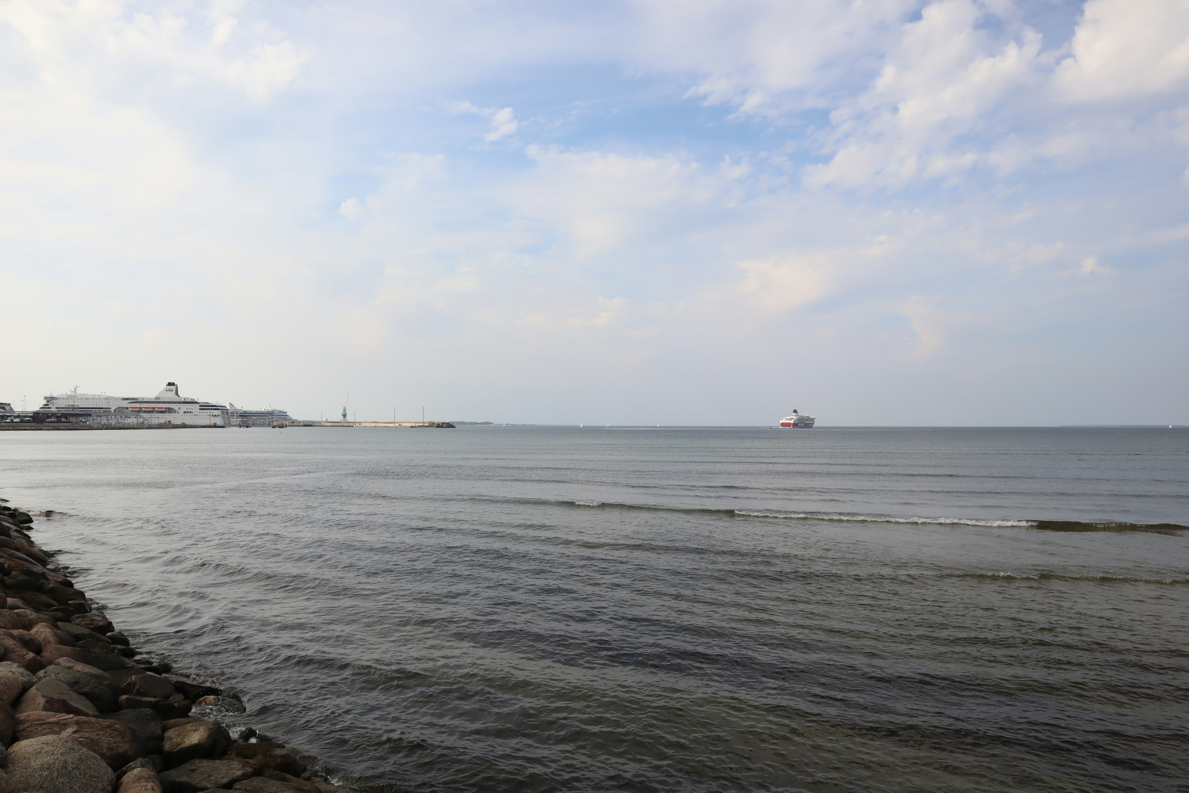 Paysage de mer calme et ciel bleu avec rivage en pierre visible