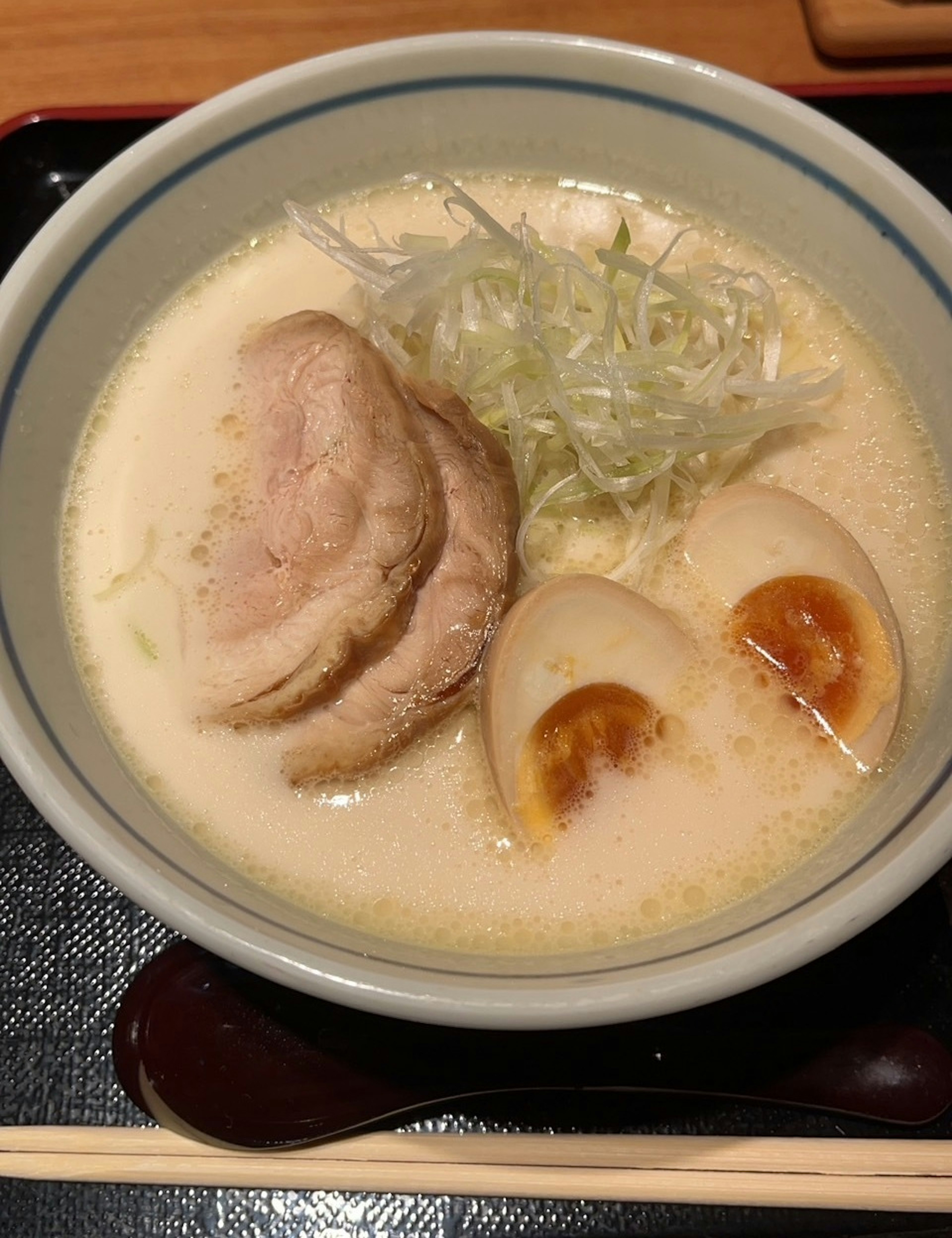 Creamy ramen soup topped with chashu and soft-boiled eggs