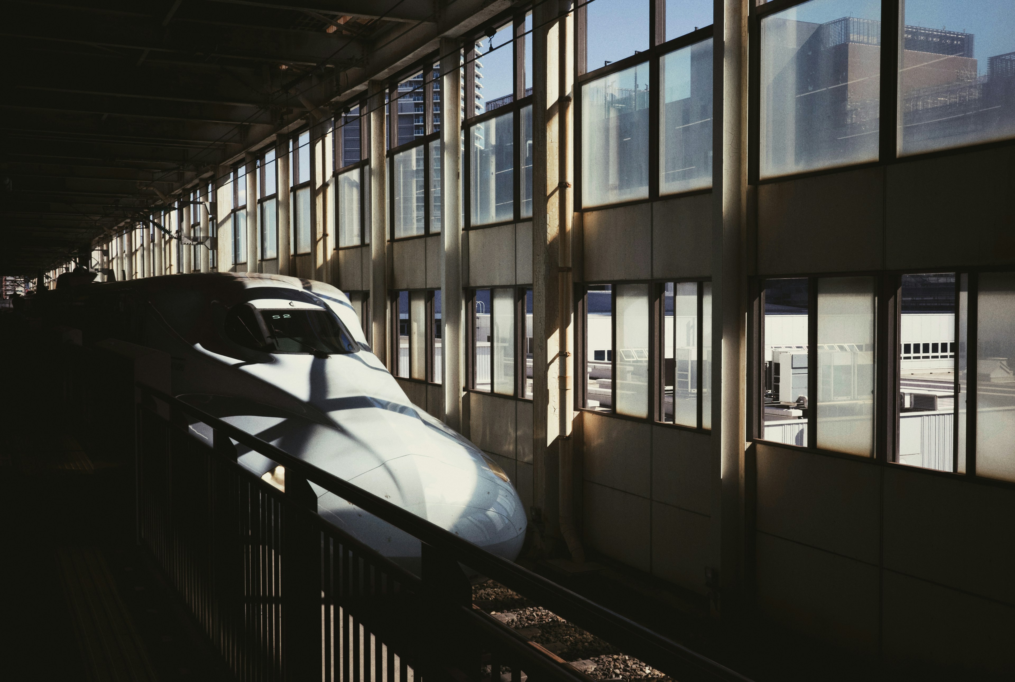 Shinkansen train parked at the station platform with natural light streaming through windows