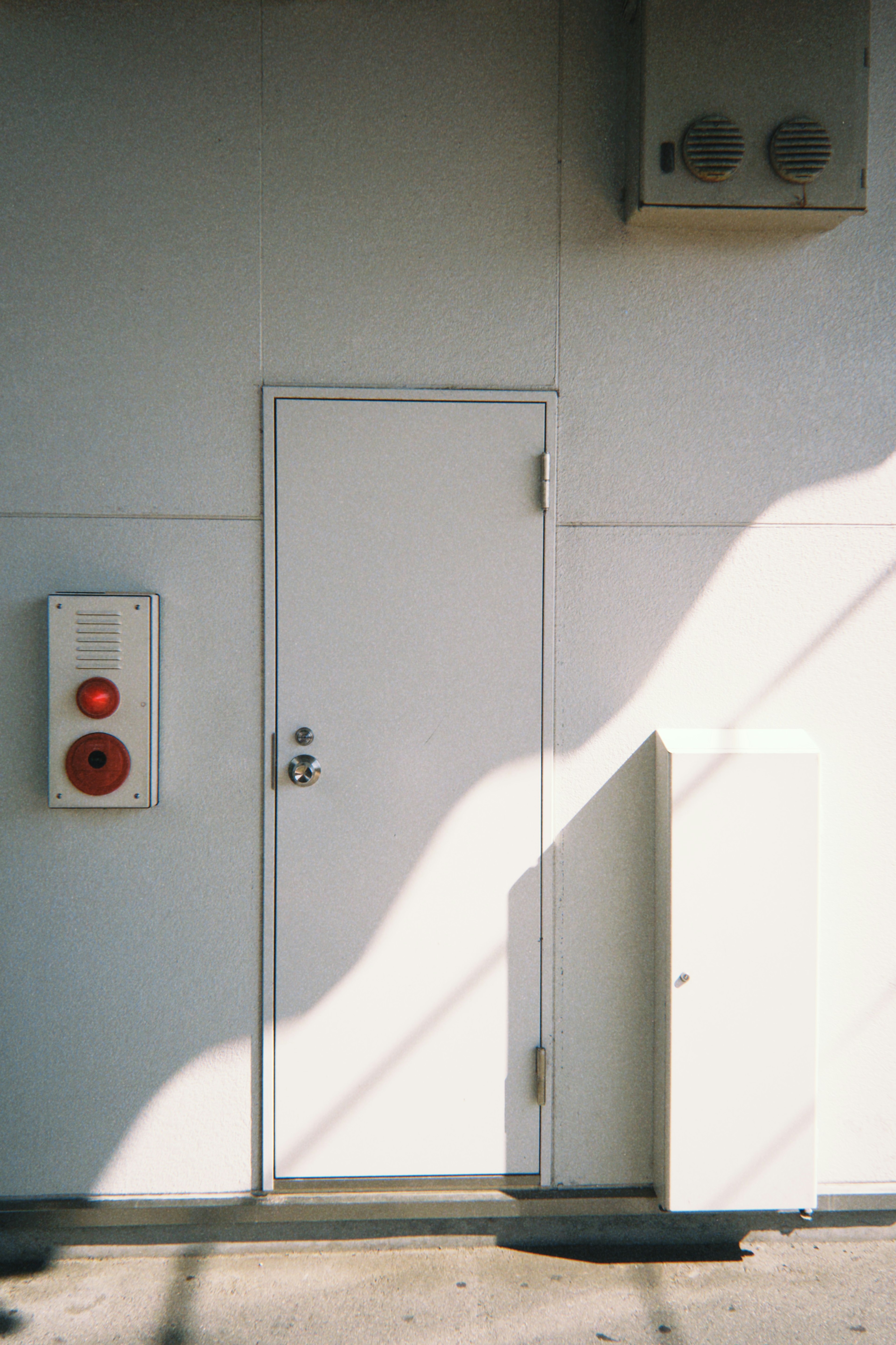 Contexte simple avec une petite porte et des feux de signalisation rouges sur un mur blanc