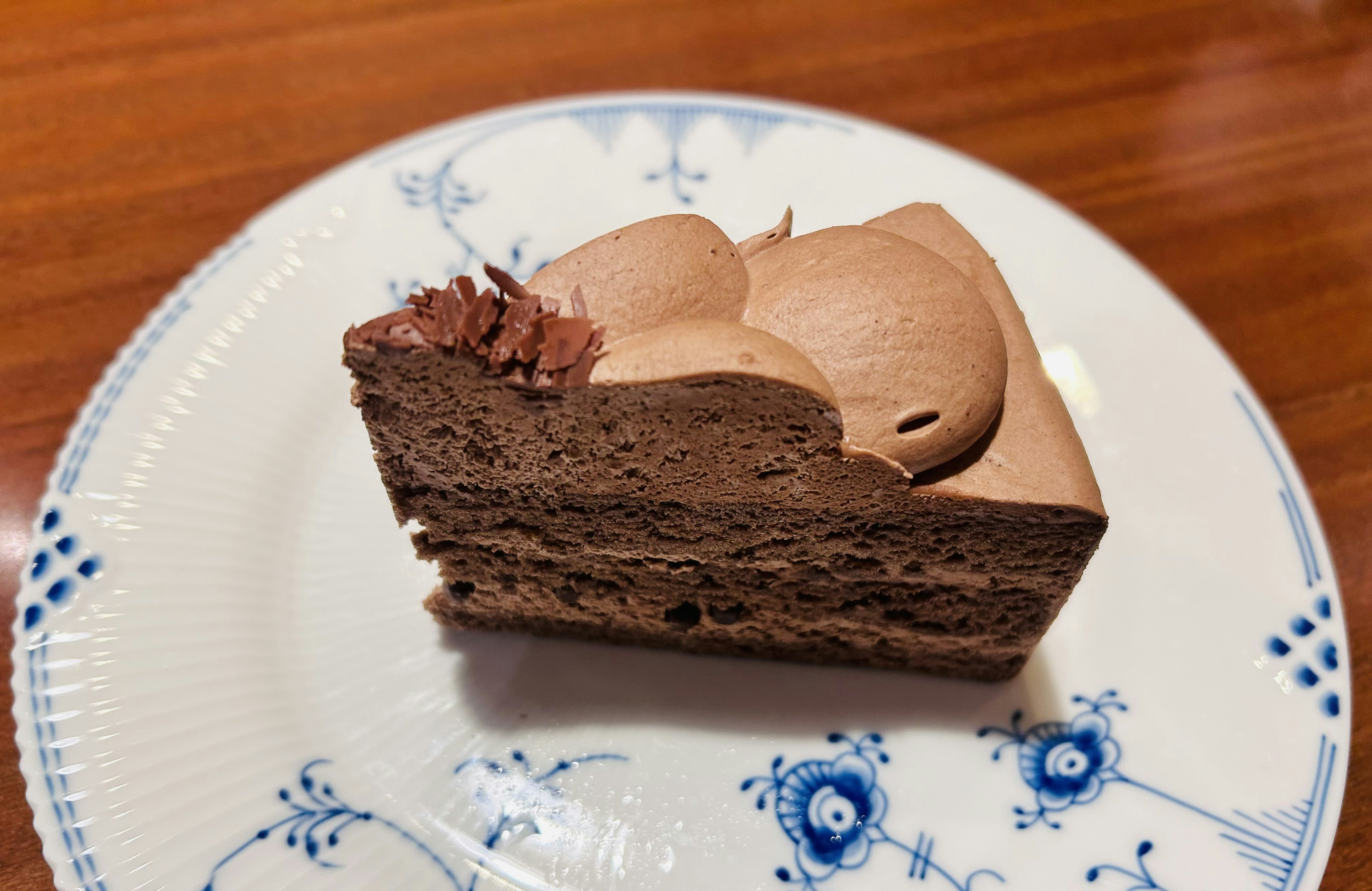 A slice of chocolate cake on a decorative plate