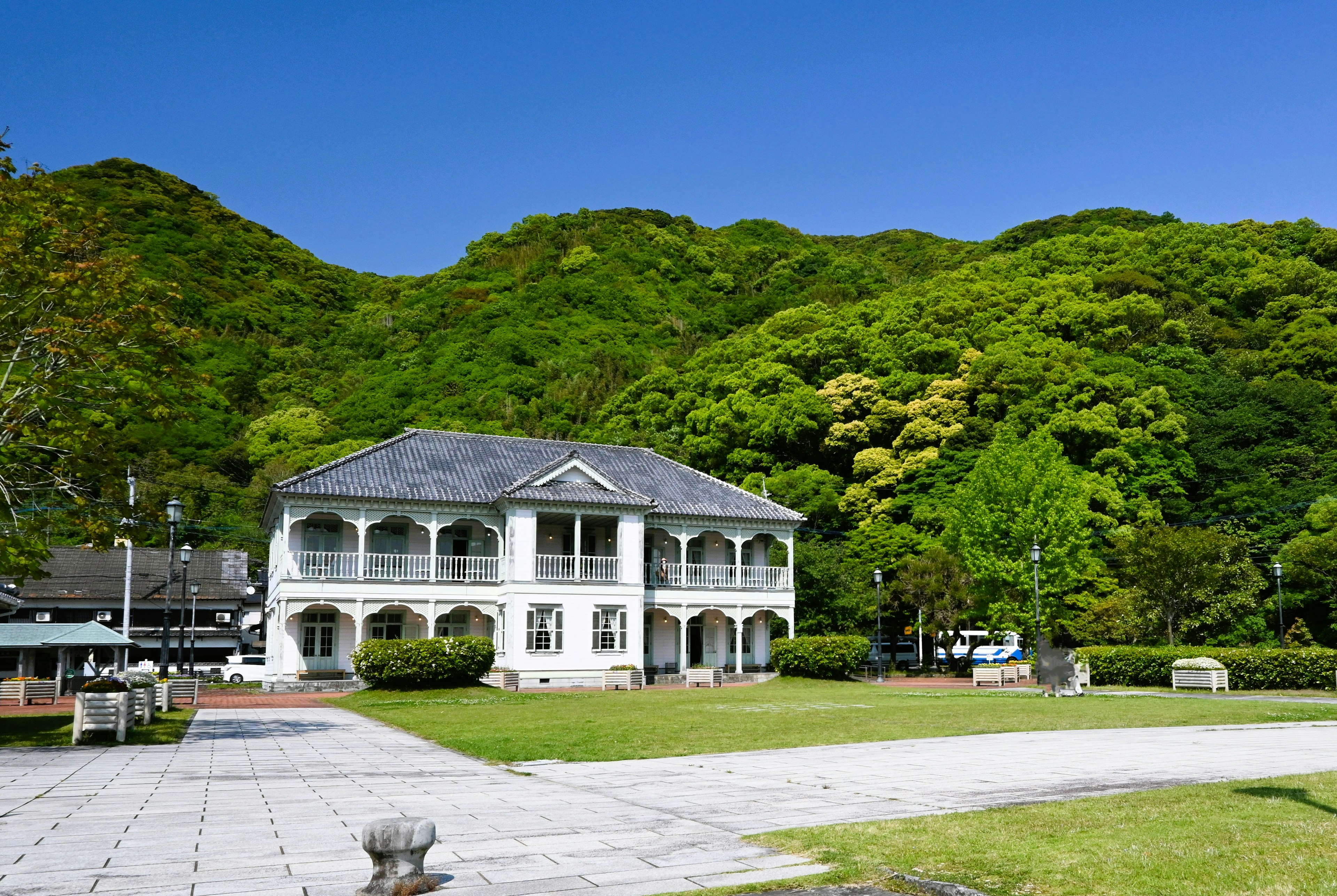 緑豊かな山々に囲まれた白い建物の風景