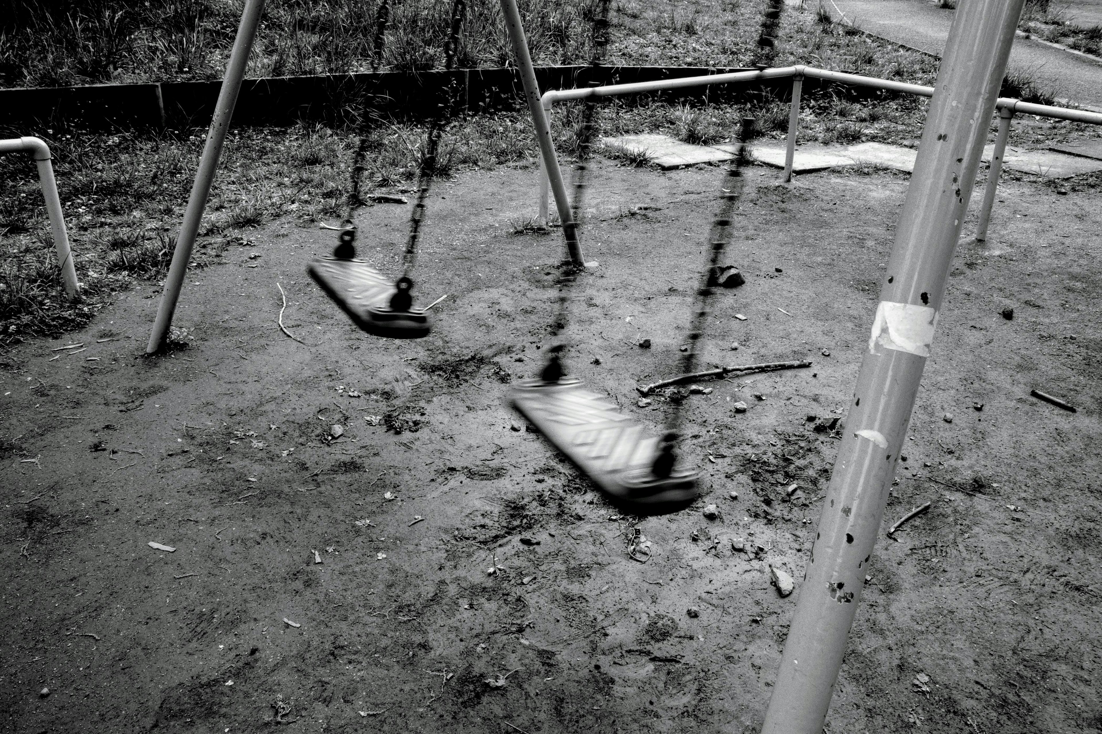 Image en noir et blanc de balançoires dans un parc