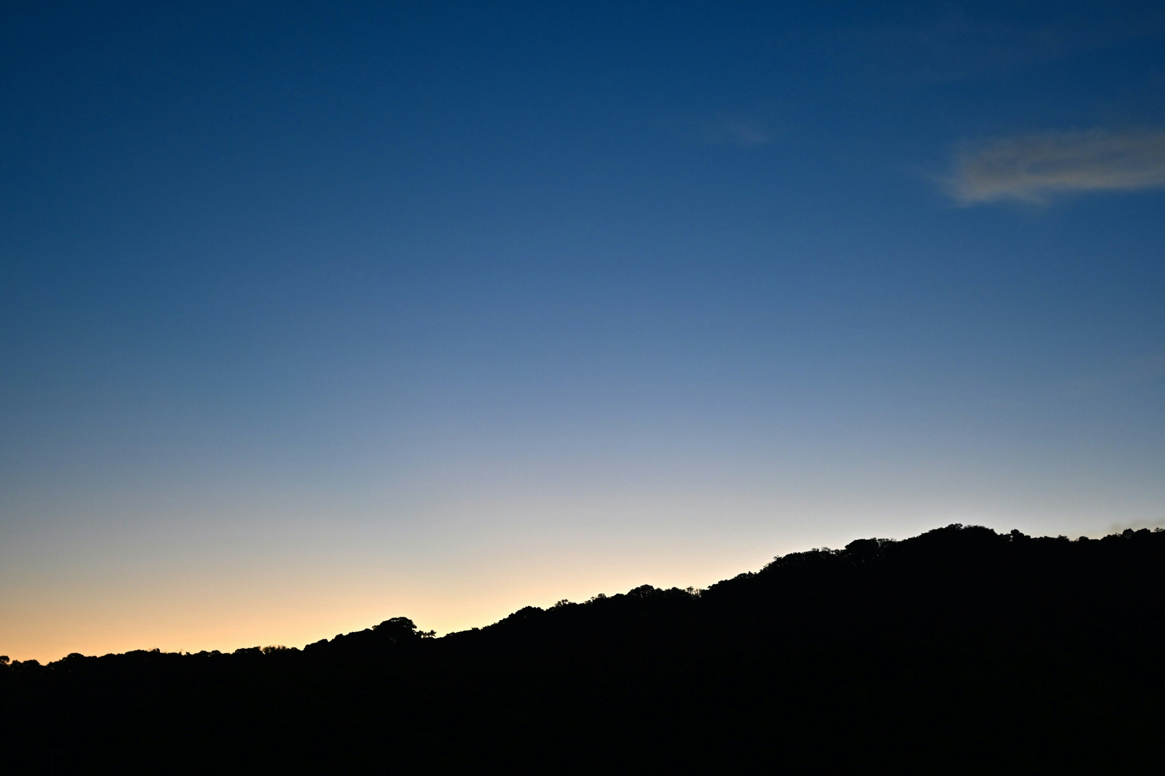 Silhouette von Bergen vor einem blauen Himmel in der Dämmerung