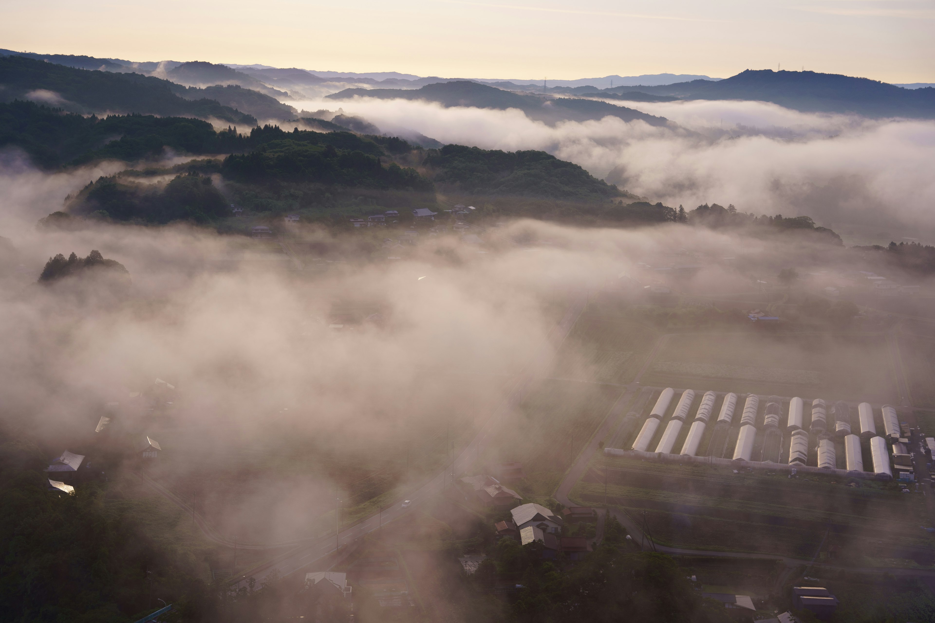 霧に包まれた山の風景と農場