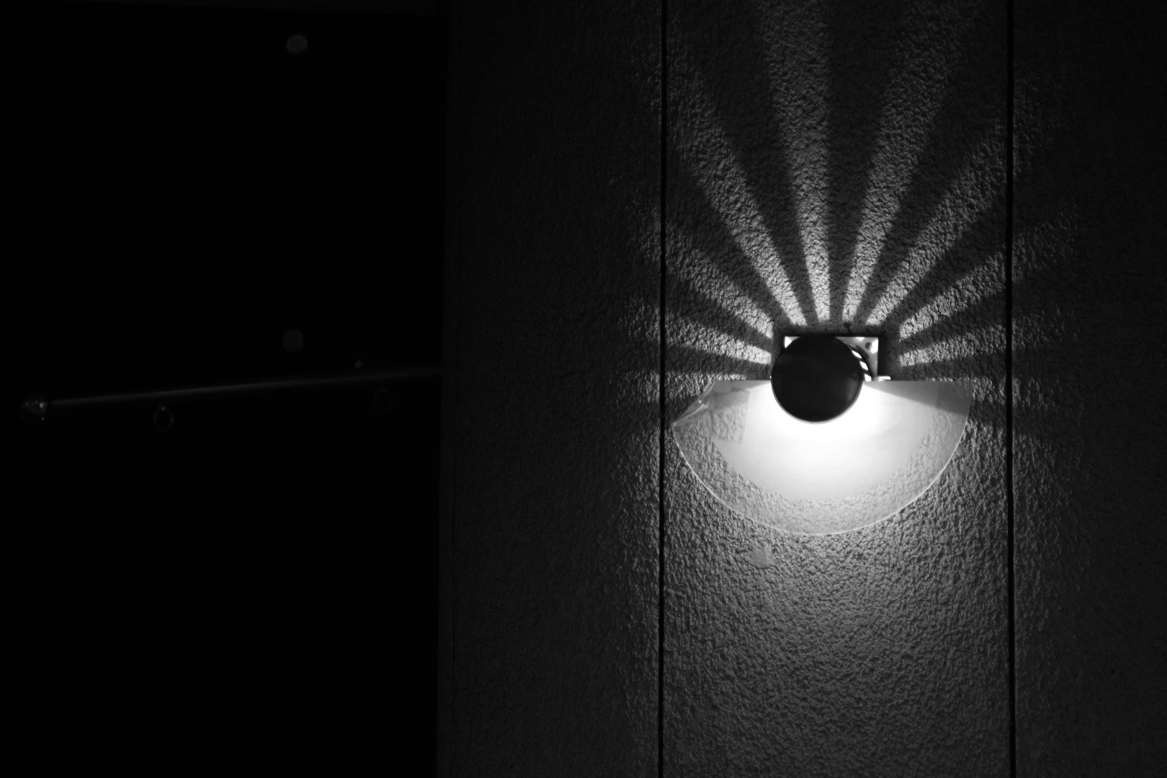 Wall-mounted light fixture casting intricate shadows