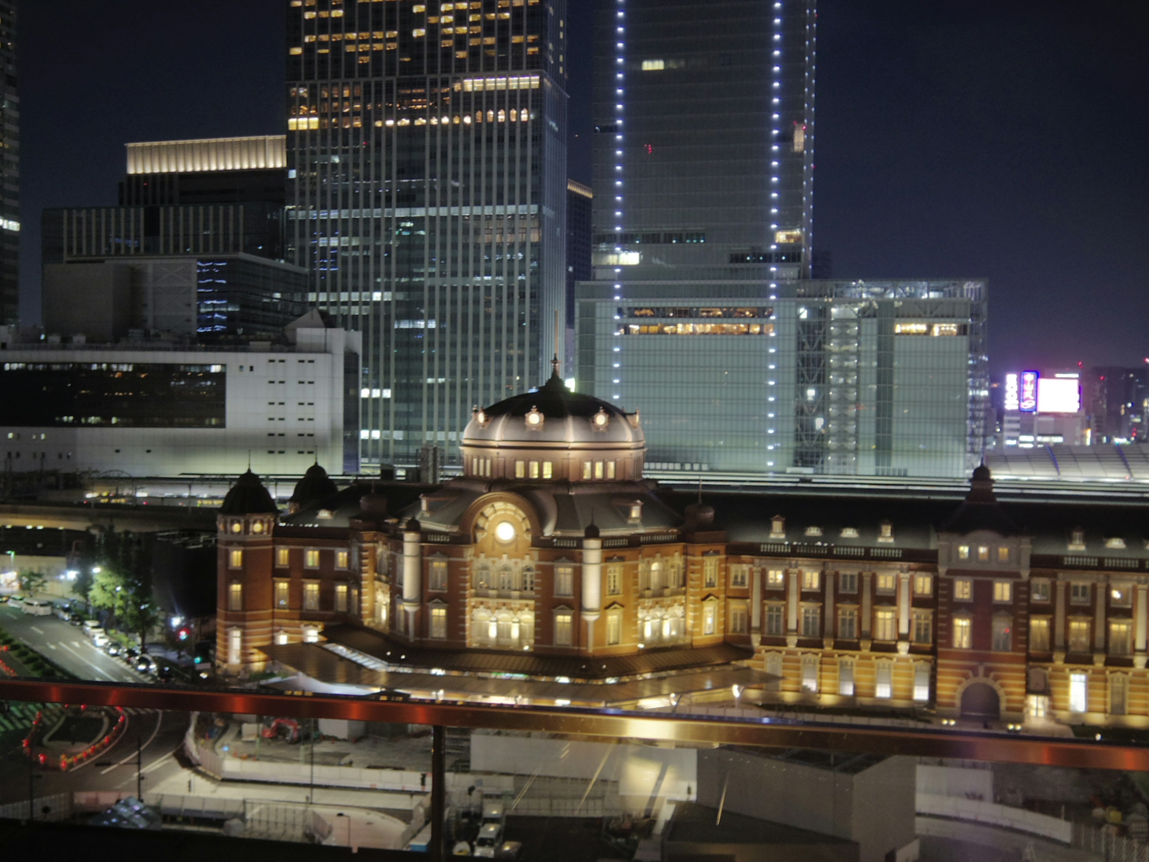 Beautiful architecture of Tokyo Station illuminated at night with modern skyscrapers