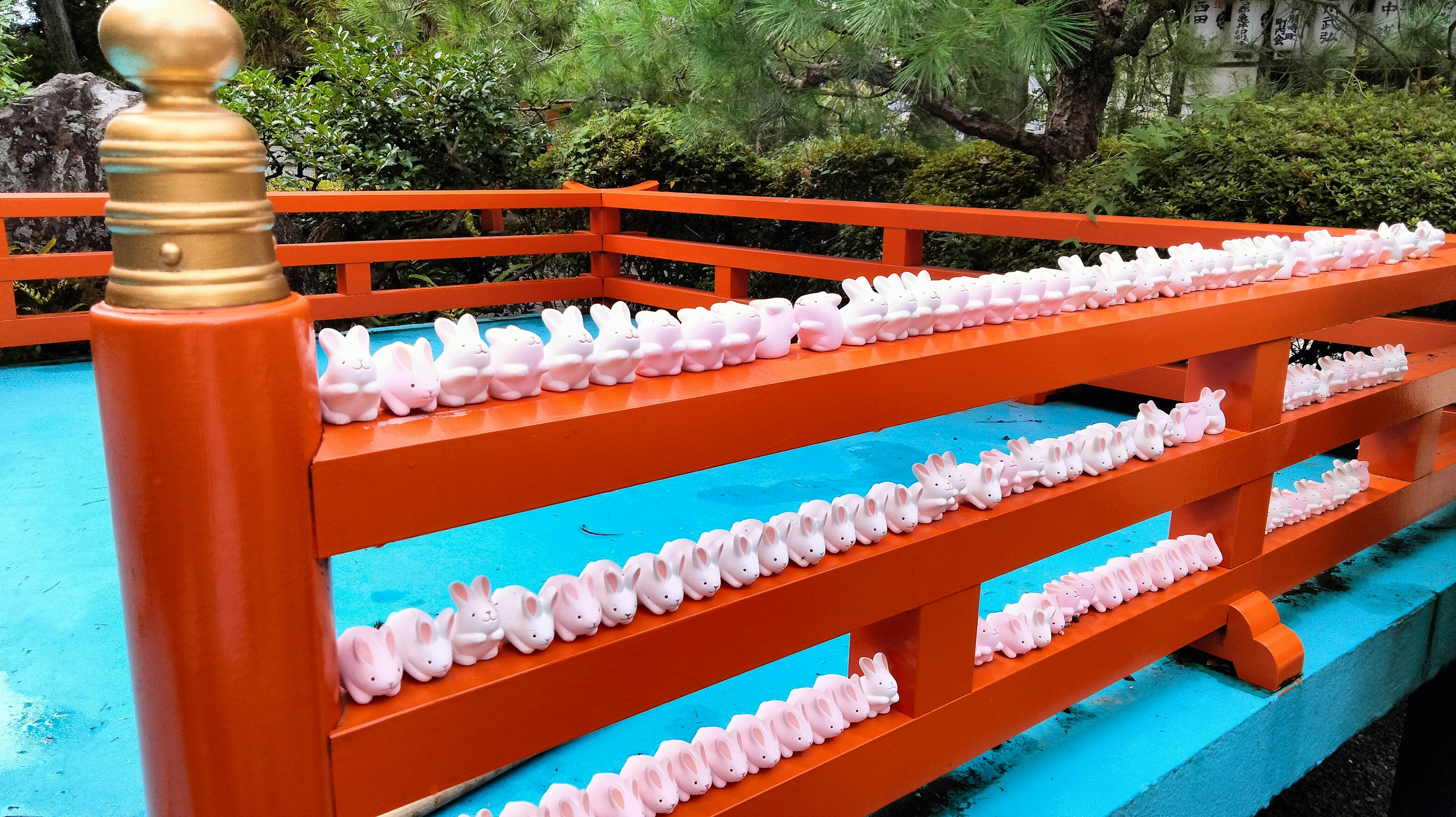 Vibrant orange railing with pink decorations on a bridge