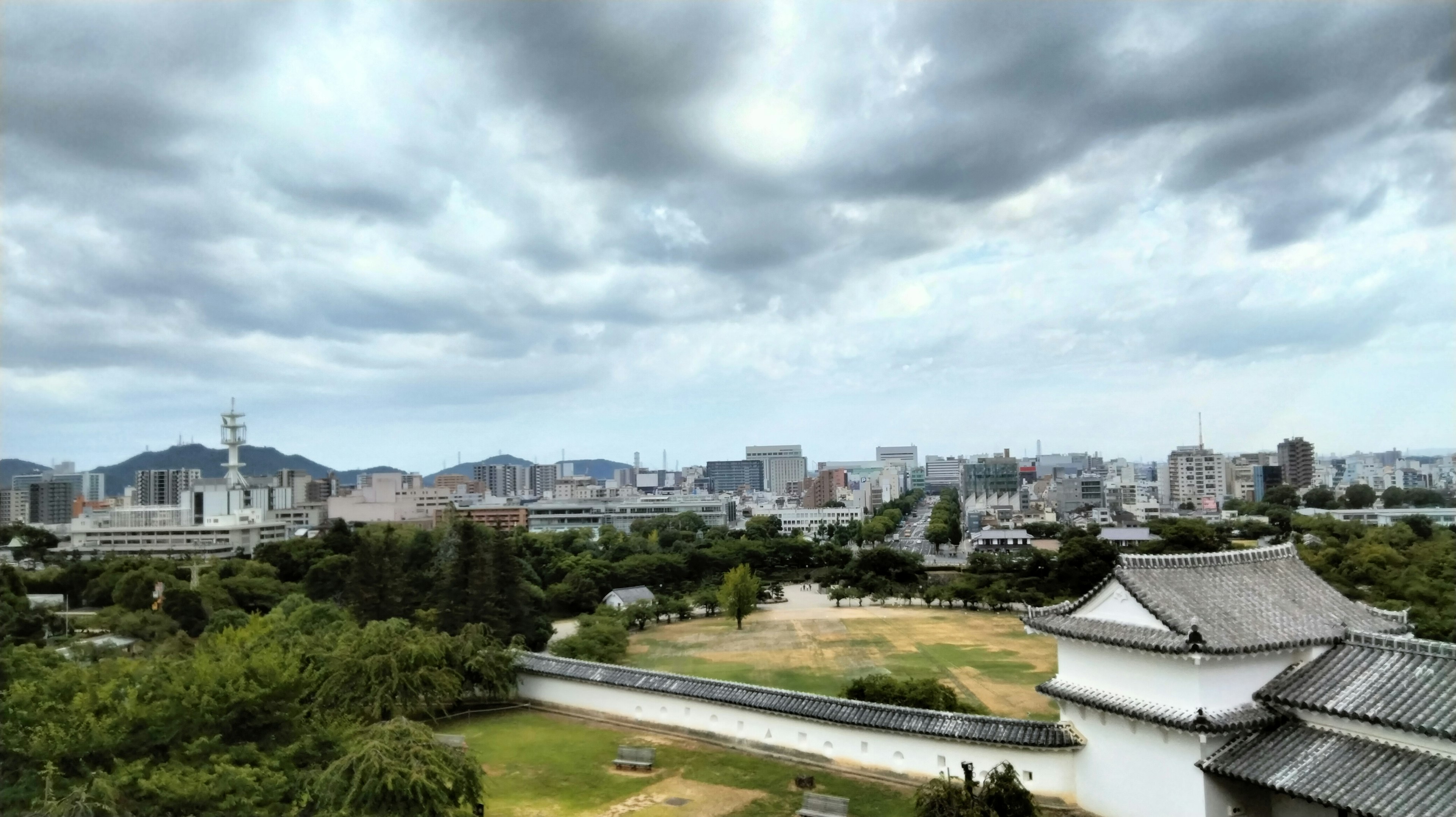 Vista del castello di Osaka con lo skyline della città sotto cieli nuvolosi