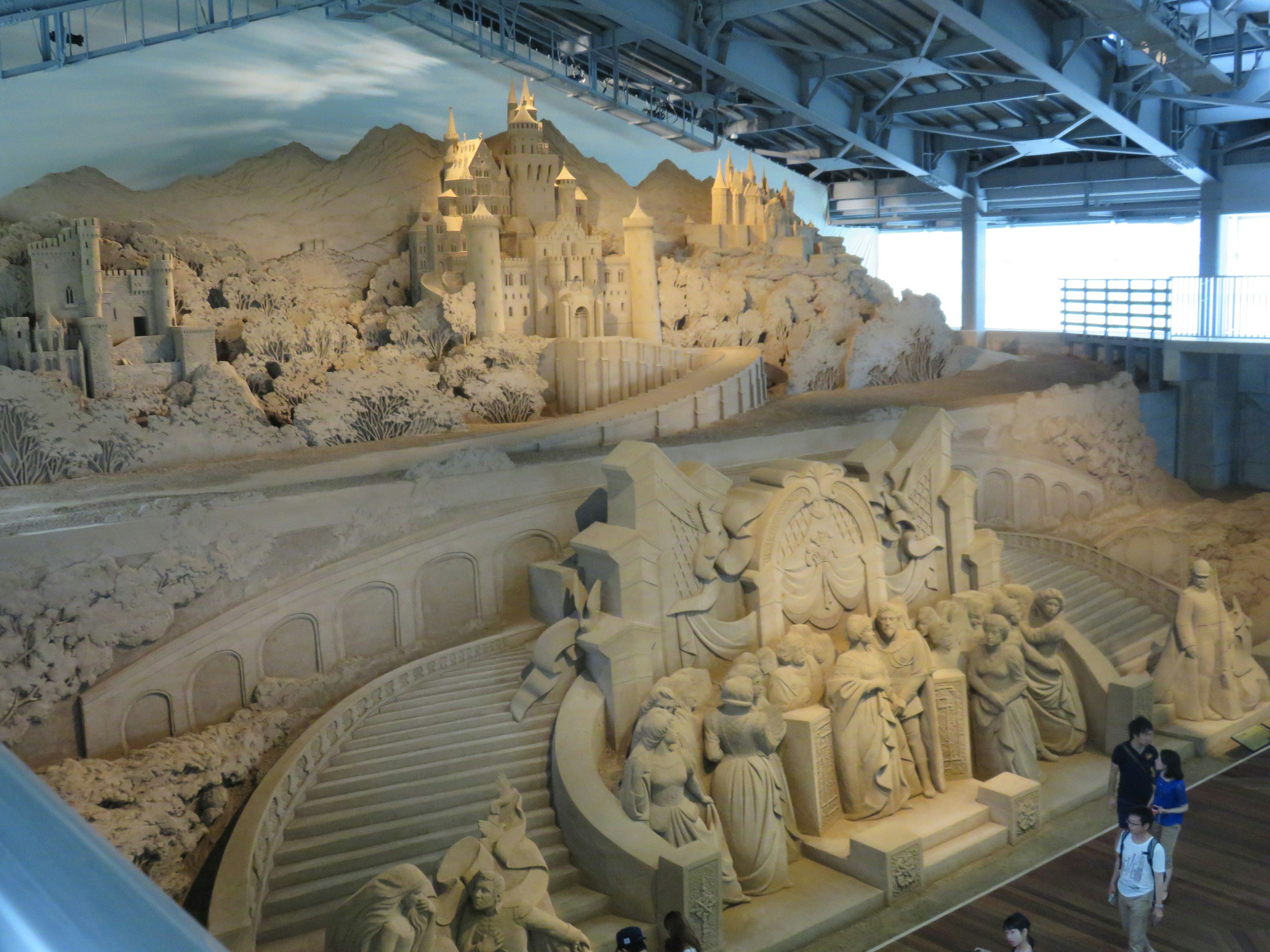 Indoor view of a massive sand sculpture exhibition featuring intricate designs